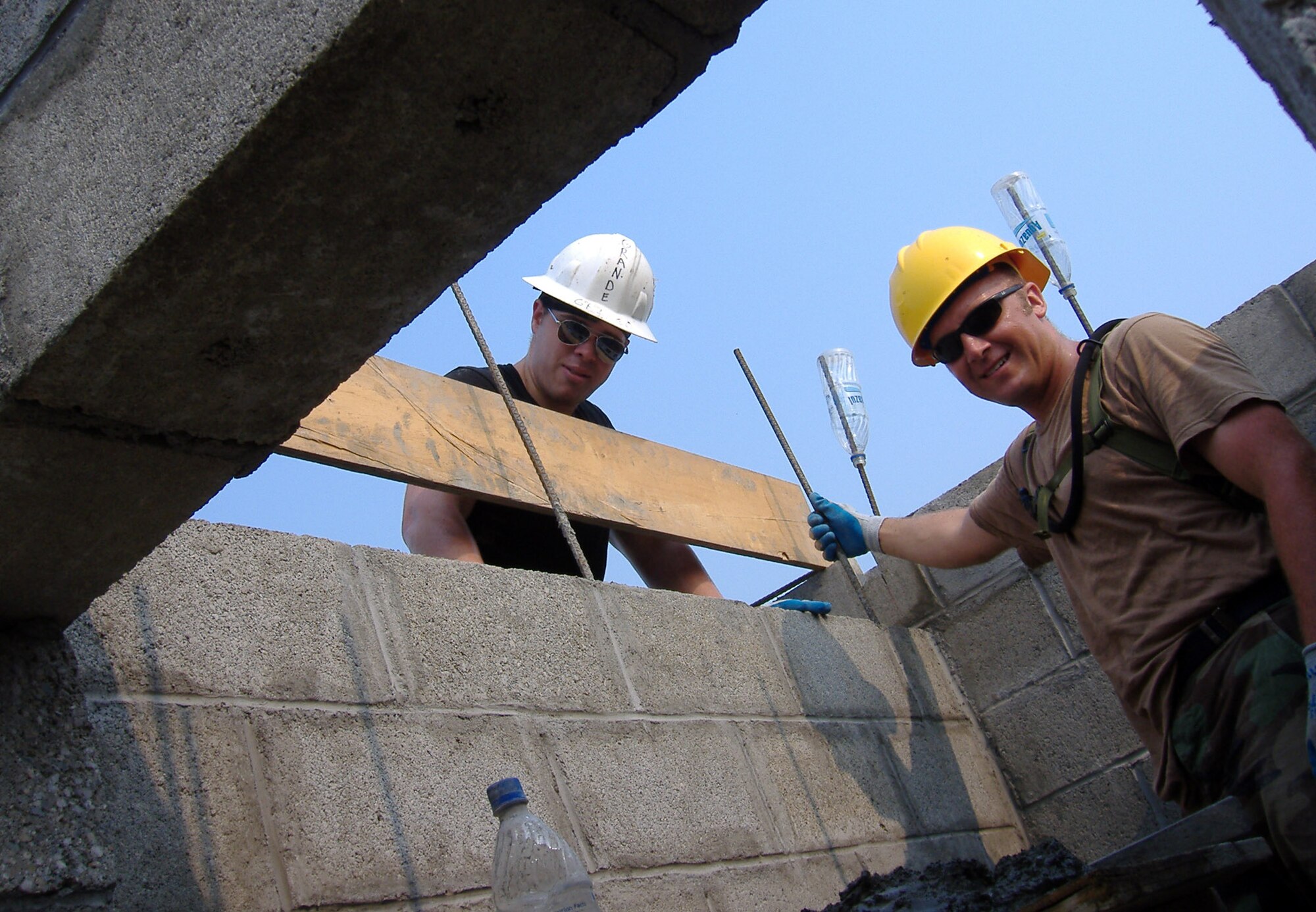 Air Force Reservists, Senior Airman Matthew Archer and Technical Sgt. Michael Trotti, 940th Civil Engineer Squadron, Beale Air Force Base, Calif., lay the final blocks for a bond beam in a new school in La Ceiba, Honduras March 20, 2006.  940 CES is part of Combined Joint Task Force New Horizons 2006 in Honduras, and is building a school for the local community.  (U.S. Air Force Photo/Capt. Rudolph Bartley) 