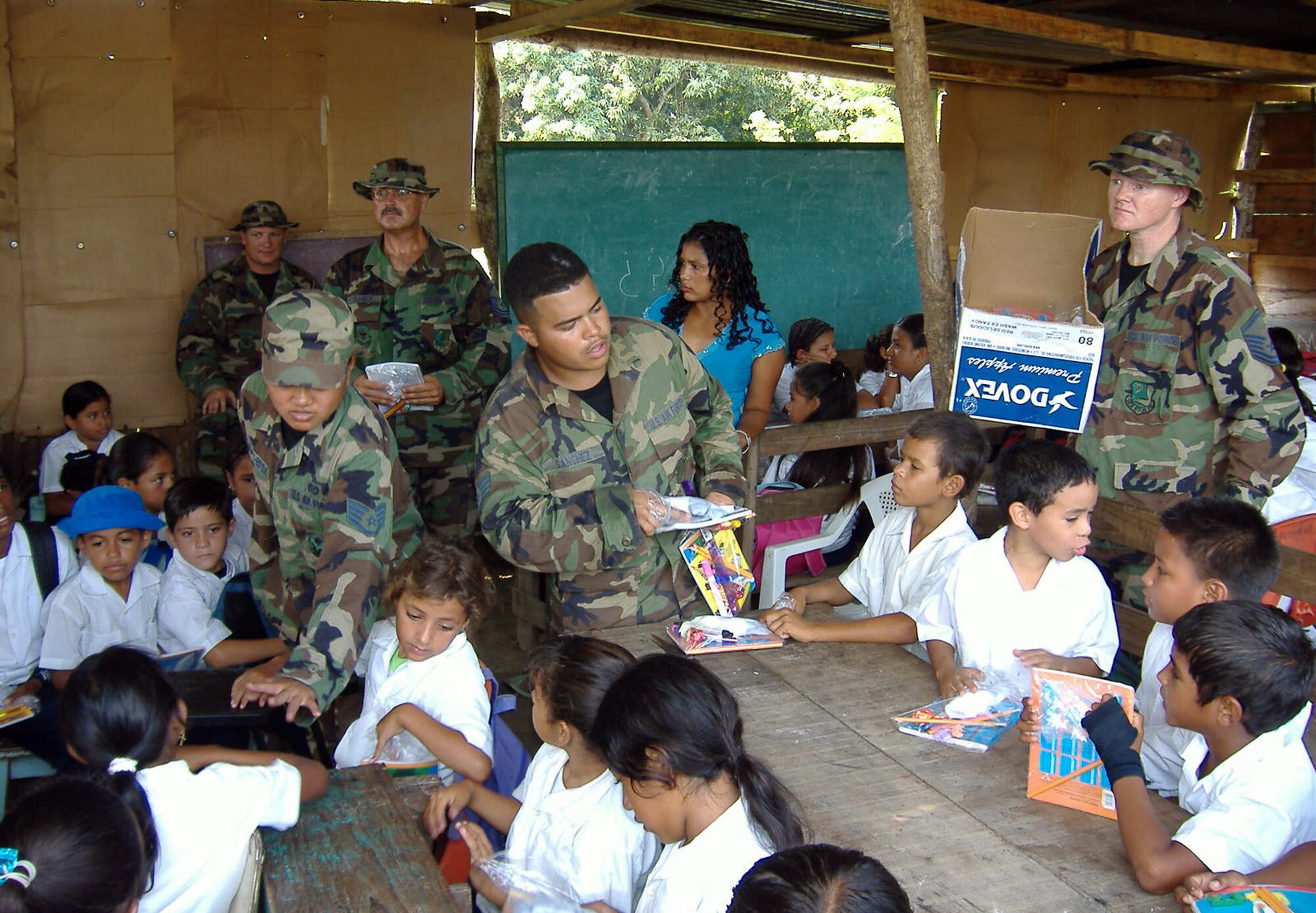 Air Force Reservists from the 940th Civil Engineer Squadron, from Beale Air Force Base, Calif., (from left to right)  Master Sgt. Frank Stroup, Staff Sgt. Tatiana Ignacio-Espejo, Master Sgt. Donald Claunch, Staff Sgt. Jason Sanchez, and Master Sgt. Daniel Fisher, hand out gifts, school supplies, toys and more to children at a school in La Ceiba, Honduras during an official visit March 18, 2006.  940 CES is part of Combined Joint Task Force New Horizons 2006 in Honduras, and is building a new school for these children. (U.S. Air Force photo/Capt. Rudolph Bartley)