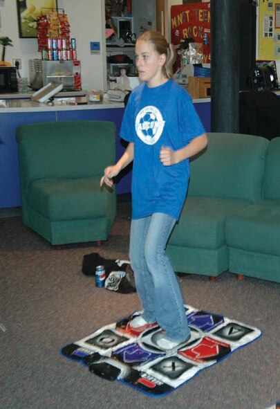 Brittany Formanek, daughter of Tech. Sgt. and Mrs. Formanek, 91st Maintenance Group, works out to Dance Dance Revolution, a video game-based program, which according to her can create quite a sweat. (U.S. Air Force photo by Senior Airman Danny Monahan)
