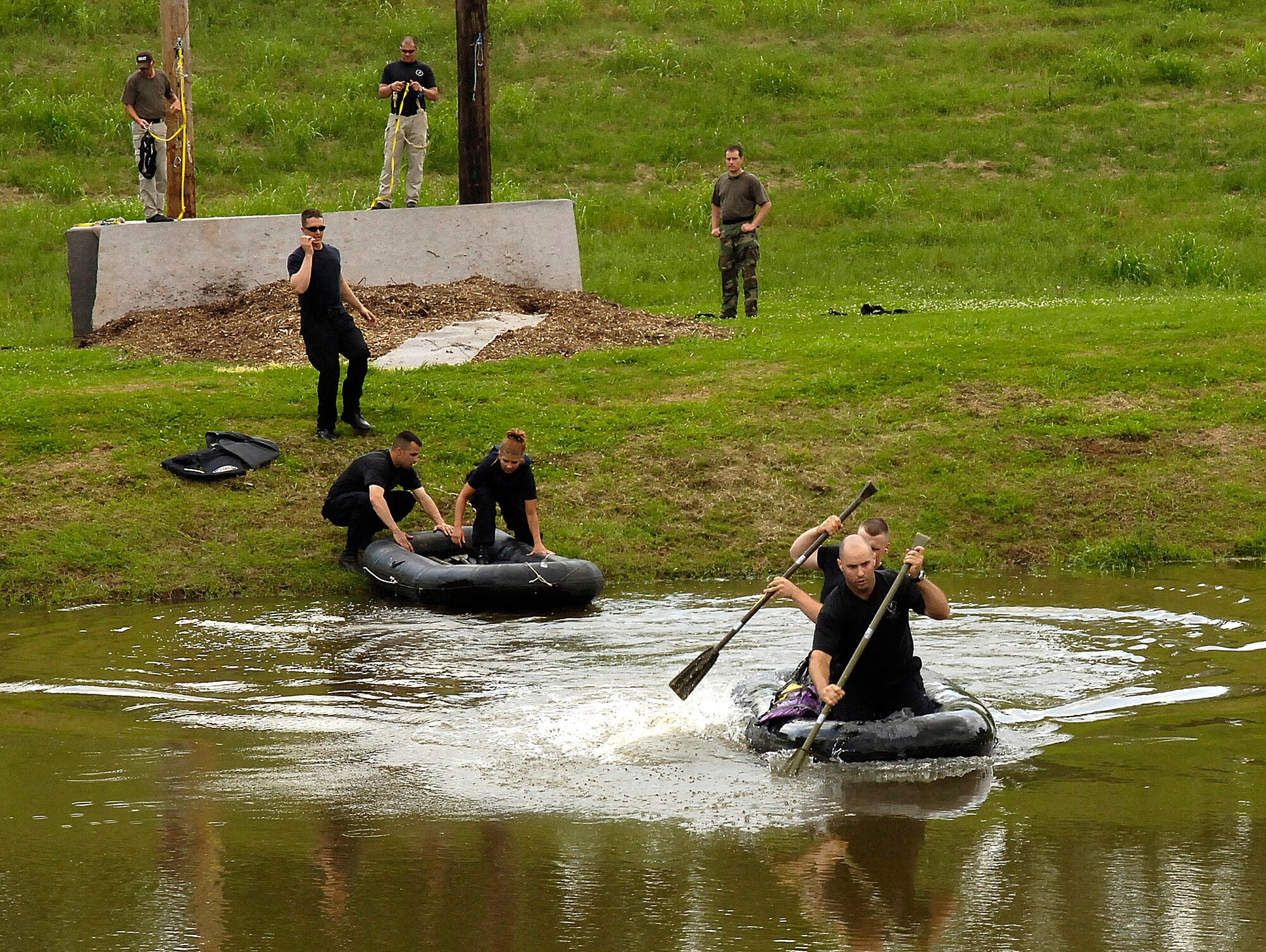 Members of the Emergency Services Team from Barksdale Air Force Base, La., race across a pond during a timed event at the Louisiana State SWAT Team Competition in Alexandria, La., on Tuesday, May 2, 2006. (U.S. Air Force photo/Senior Airman Stephen J. Otero) 