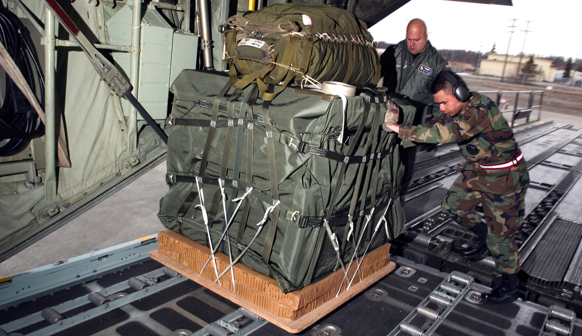 Senior Airman Marvin Poquiz and Tech. Sgt. Chuck Brynteson load container delivery systems onto a C-130 Hercules at Elmendorf Air Force Base, Alaska, as part of Red Flag-Alaska 06-2 exercises on Friday, April 28, 2006. Poquiz is with the 732nd Air Mobility Squadron at Elmendorf. Sergeant Brynteson is with the 96th Airlift Squadron at Minneapolis-St. Paul Joint Air Reserve Station, Minn. (U.S. Air Force photo/Senior Airman Garrett Hothan)