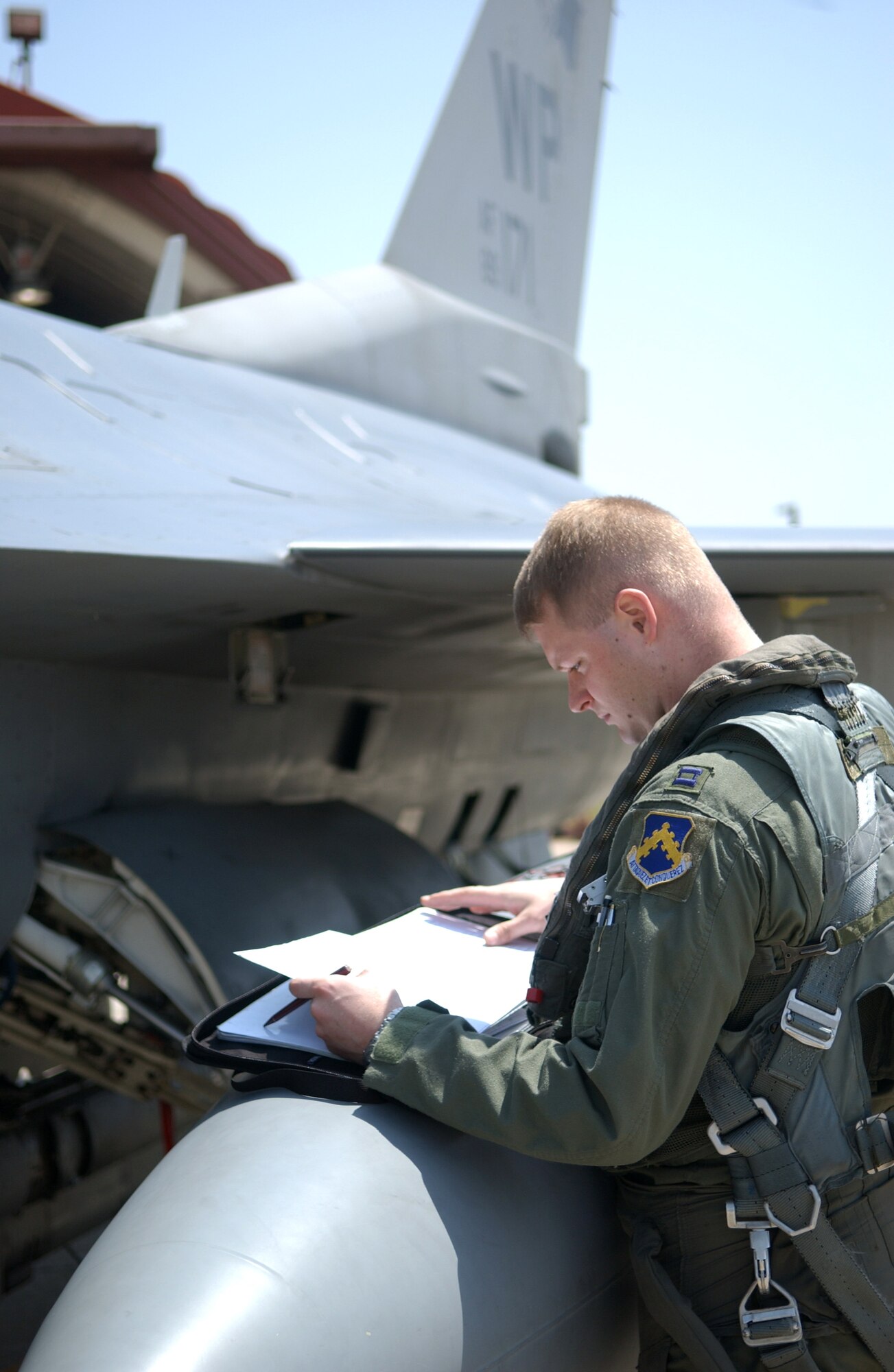 Capt. Lynn Savage reviews the maintenance log of an F-16 Fighting Falcon before a training mission on Friday, April 28, 2006. Captain Savage is assigned to the 35th Fighter Squadron at Kunsan Air Base, South Korea. (U.S. Air Force photo/Master Sgt. Richard Freeland)
