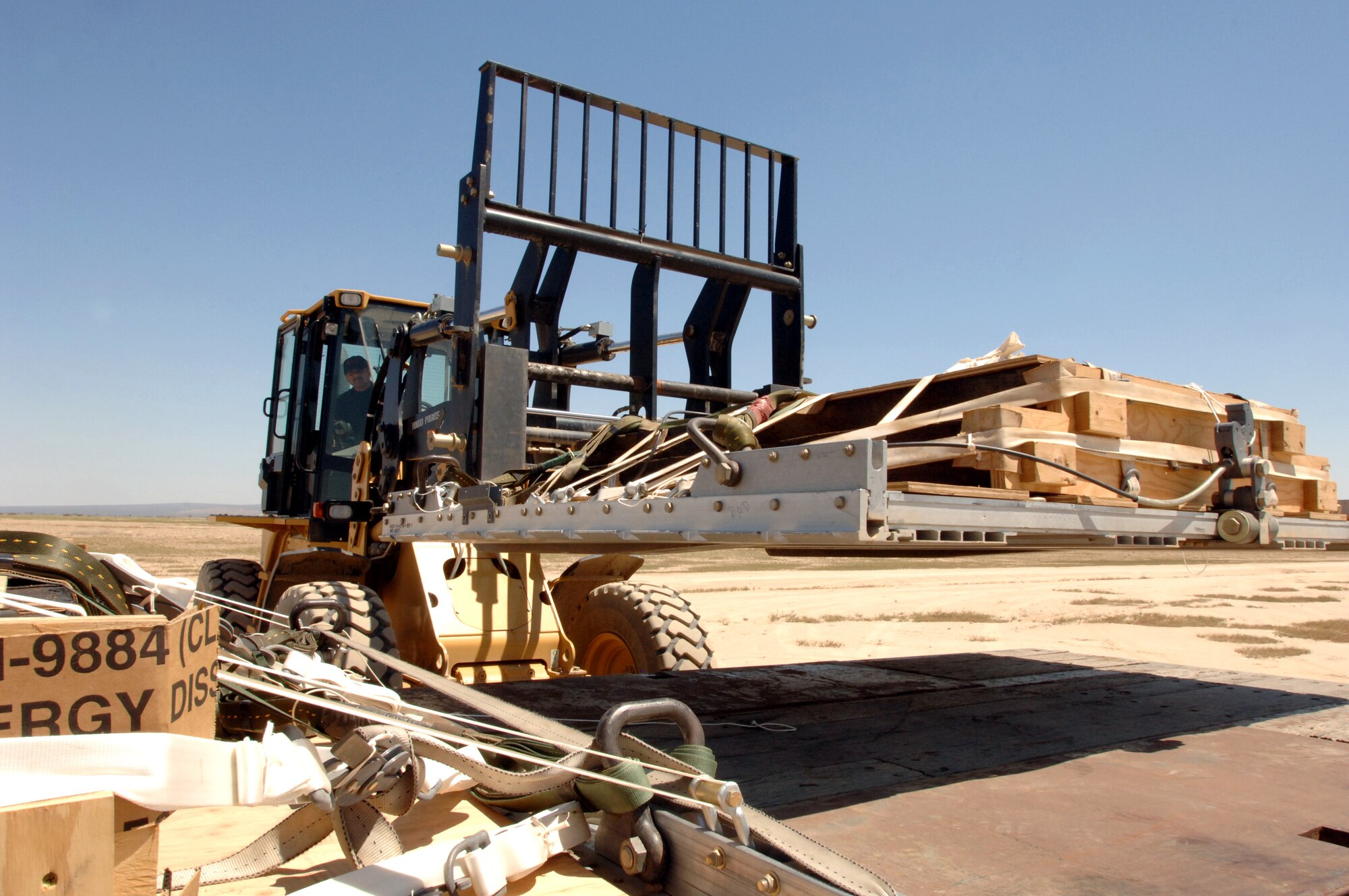 Master Sgt. Ruben Camacho loads a Type 5 heavy pallet onto a truck at Edwards Air Force Base, Calif., after it was dropped by a C-130J Hercules on Sunday, April 30, 2006. The mission was part of a test to certify the aircraft's capability to drop this type of pallet. Guard, Reserve and active-duty aircrews from Channel Islands Air National Guard Base, Calif.; Little Rock AFB, Ark.; and Keesler AFB, Miss., participated in the certification. This was the first time the "J" model dropped a Type 5 pallet. Sergeant Camacho is with the 146th Aerial Port Squadron at Channel Islands ANGB. (U.S. Air Force photo/Tech. Sgt. Dave Buttner)