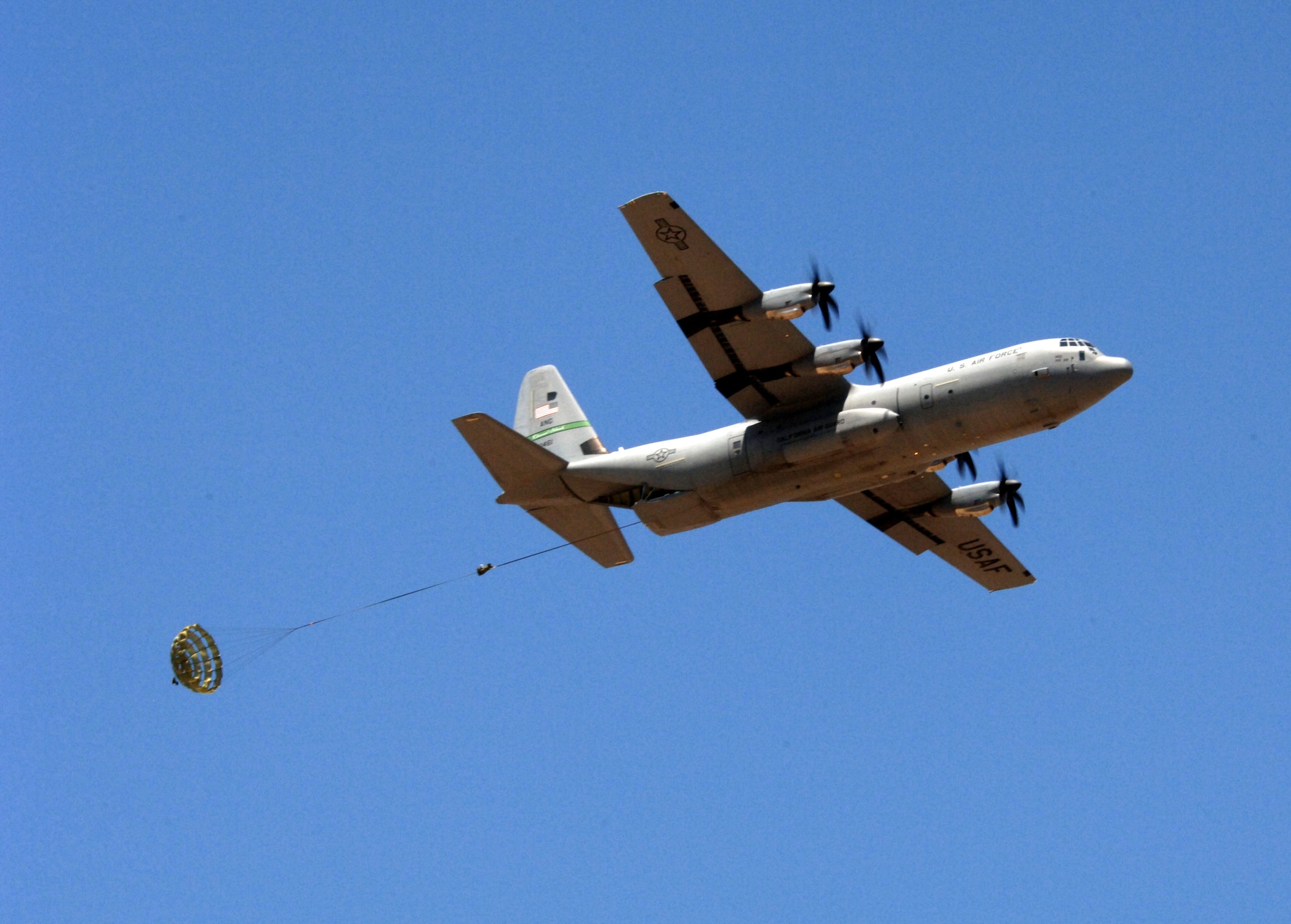 A C-130J Hercules flying over Edwards Air Force Base, Calif., on Sunday, April 30, 2006, deploys a drogue parachute that will extract a Type 5 heavy pallet. The mission was part of a test to certify the aircraft's capability to drop this type of pallet. Guard, Reserve and active-duty aircrews from Channel Islands Air National Guard Base, Calif.; Little Rock AFB, Ark.; and Keesler AFB, Miss., participated in the certification. This was the first time the "J" model dropped this type of pallet. (U.S. Air Force photo/Tech. Sgt. Dave Buttner)