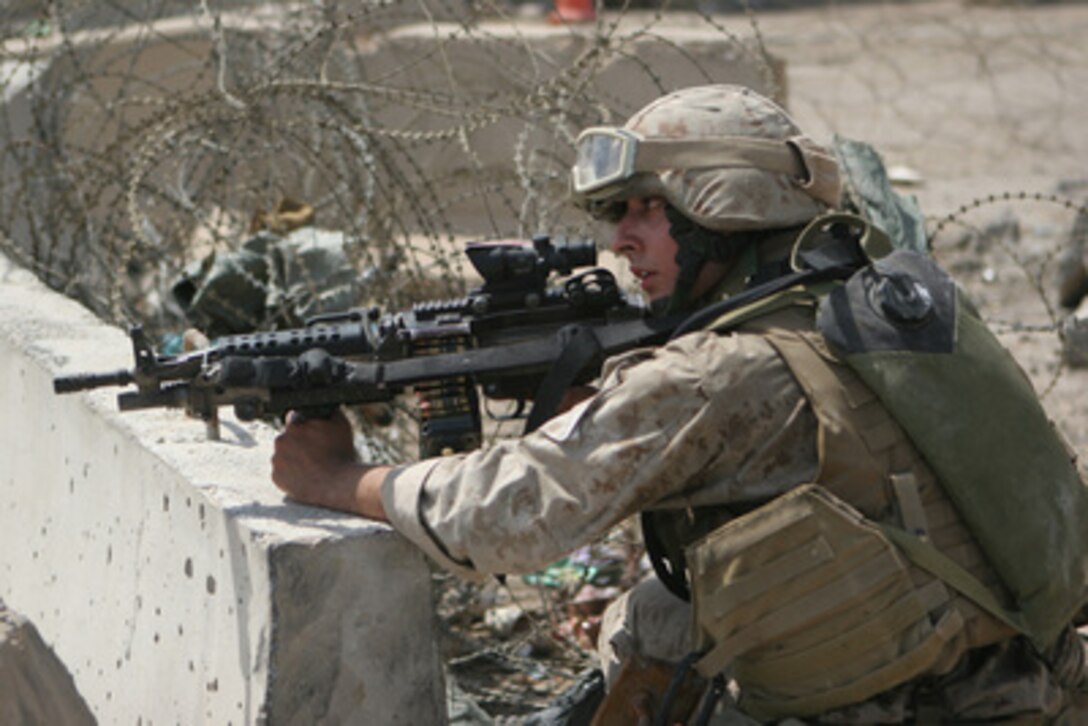 U.S. Marine Corps Lance Cpl. Jeff Ortiz kneels behind cover during a mission to search for weapons caches in Ar Ramadi, Iraq, on April 20, 2006. Ortiz is assigned to 1st Platoon, India Company, attached to Kilo Company, 3rd Battalion, 8th Marine Regiment. 