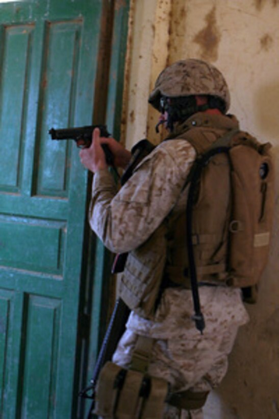 U.S. Marine Corps Sgt. Jonathon D. Lewis enters to clear and search a room in an abandoned house during a patrol near the town of Al Ish, Iraq, on April 29, 2006. Lewis is with Weapons Company, 1st Battalion, 7th Marines Regiment. 