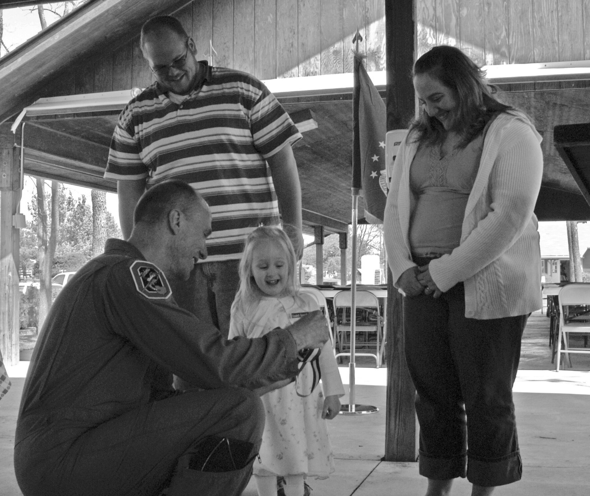 Col. Mike Roberts, Ohio Air National Guard's 178th Fighter Wing vice commander, presents Elizabeth Koerner, 3, with a Young Heroes Medal of Honor as her parents, Matthew and Hannah Koerner, look on. (Air Force photo by 2nd Lt. Holly Layer)

