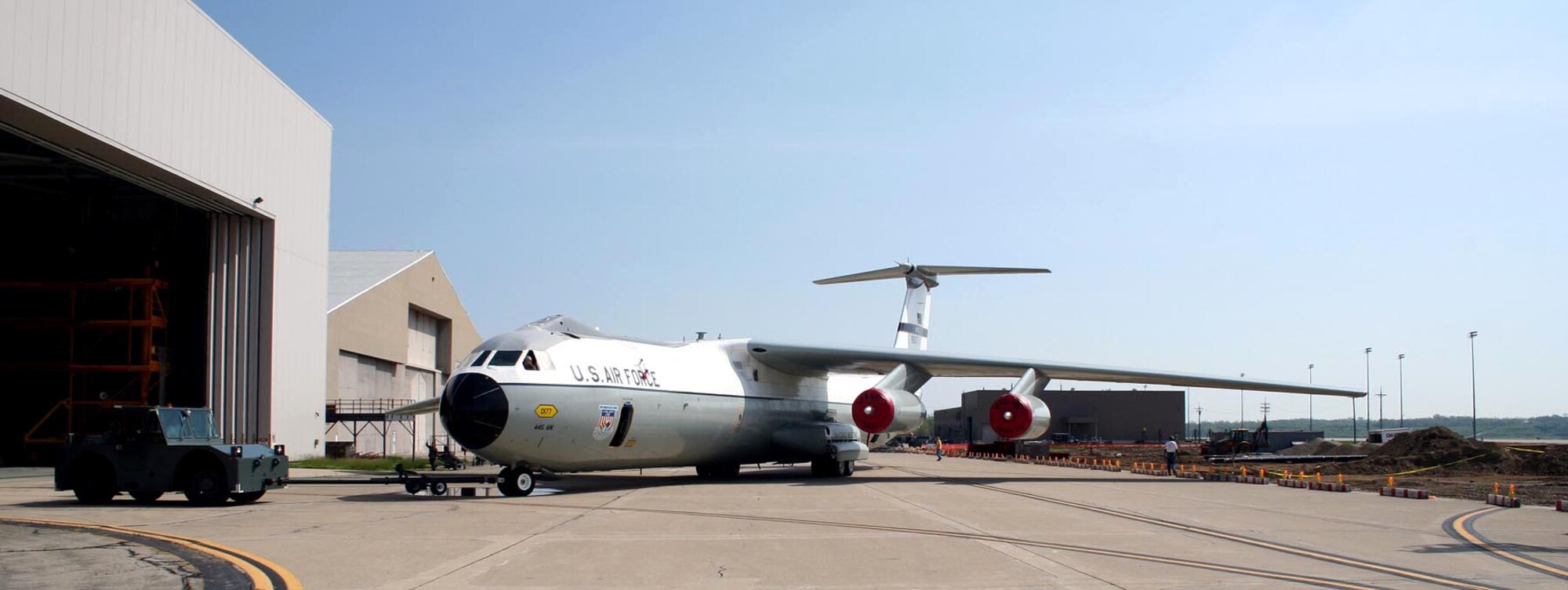 A maintenance tug pushes the C-141 Starlifter known as the "Hanoi Taxi" out of a maintenance hangar at Wright-Patterson Air Force Base, Ohio, on Wednesday, May 3, 2006.  The aircraft is set for retirement and dedication at the National Museum of the United States Air Force in Dayton, Ohio, on May 6.  (U.S. Air Force photo)