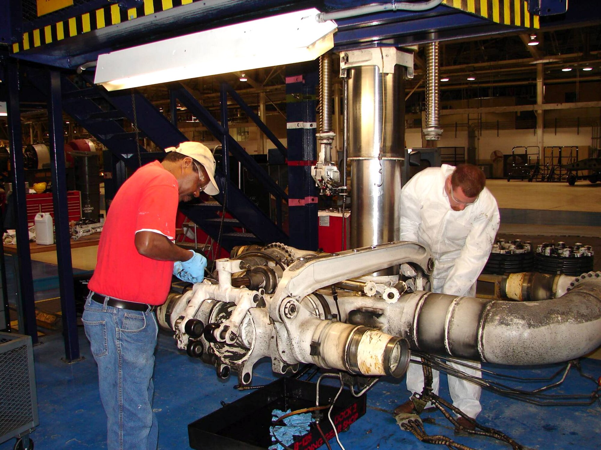 Monroe Allen (left) and Jessie Walker tear down a C-5 Galaxy main landing gear at Robins Air Force Base, Ga. The Warner Robins Air Logistics Center received the 2006 Franz Edelman Award for Achievement in Operations Research on Monday, May 1, 2006, for its use of operations research to streamline maintenance procedures for the C-5. Using innovative management processes, the time required to repair and overhaul the aircraft was reduced 33 percent. Mr. Allen and Mr. Walker work in the center's C-5 landing gear shop (U.S. Air Force photo/James Morrow)
