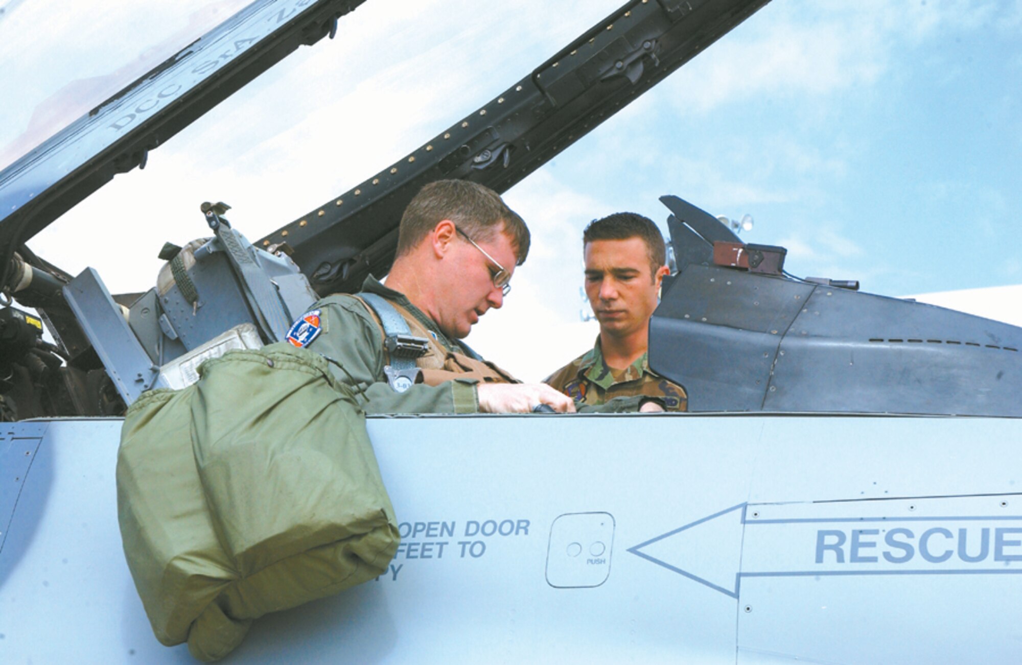 CANNON AIR FORCE BASE, N.M. - Lt. Col. Brad Kearney, 523rd Fighter Suadron, straps into his F-16 and goes final checks with Senior Airman Jonathan Cartwright, 523rd Aircraft Maintenance Squadron, before his flight to Nellis Air Force Base, Nev. (U.S. Air Force photo by Staff Sgt. April Wickes)