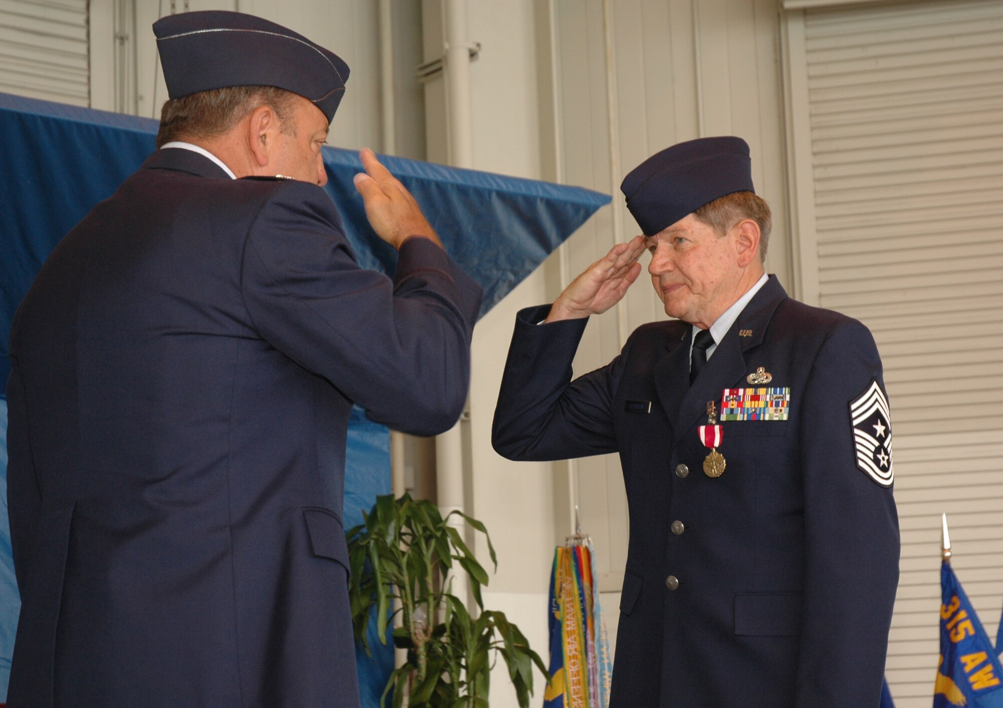 The 315th Airlift Wing Command Chief Master Sgt. Michael Petersen gives Col. Gary Cook, 315th AW commander, a final salute during his award presentation and retirement ceremony.  Photo by 1st Lt. Wayne Capps, USAFR