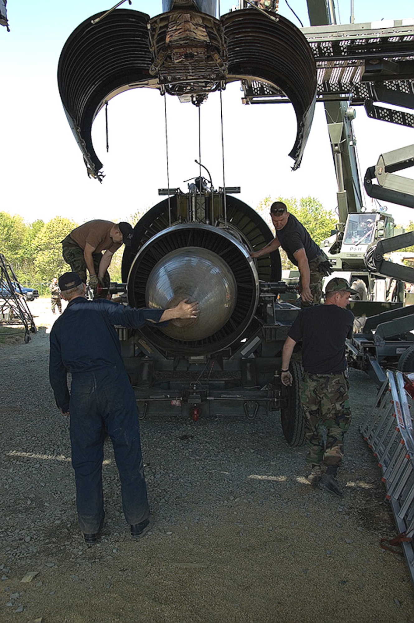 (Clockwise from top left) Staff Sgts. James Leslie and Mark Rose and Tech. Sgts. Peter Magagnotti and Bryan Hooper remove an engine on Friday, April 28, 2006, from the C-5 Galaxy that crashed at Dover Air Force Base, Del., April 3. Although the engine is off the plane, it will remain at the site along with the other parts until cleared for release by the accident investigation board. Sergeants Leslie and Hooper are with the 512th Component Maintenance Squadron. Sergeants Rose and Magagnotti are with the 436th Maintenance Squadron. (U.S. Air Force photo/Roland Balik)