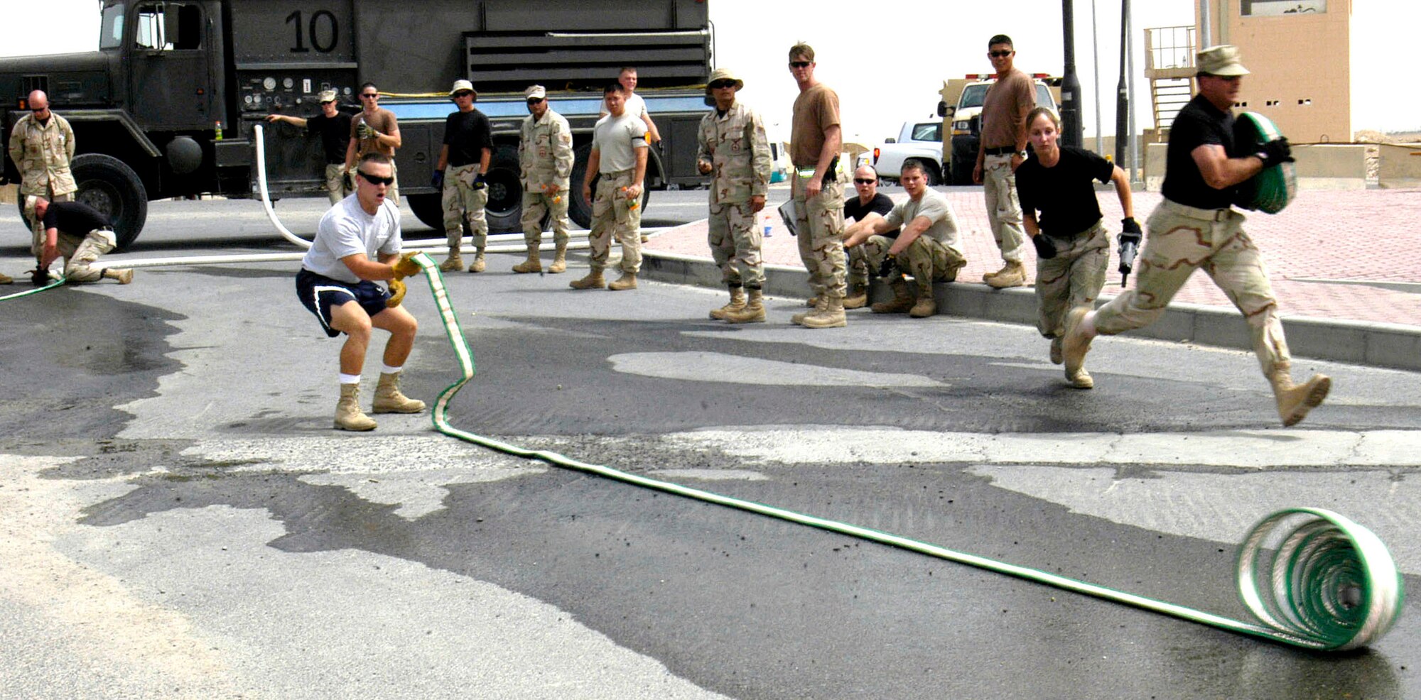 Staff Sgt. Shaun Lyle rolls out a hose during the Firefighter Challenge in Southwest Asia on Thursday, May 4, 2006. More than 36 Airmen, Marines and Soldiers participated in the event, which was hosted by the 386th Air Expeditionary Wing fire and emergency services flight. Individual and team events included climbing a 40-foot tower to hoist a 40-pound hose and pulling a hose 75 feet, which when extended weighs more than 270 pounds. Sergeant Lyle is with the 386th Expeditionary Civil Engineer Squadron. (U.S. Air Force photo/Staff Sgt. Jasmine Reif)