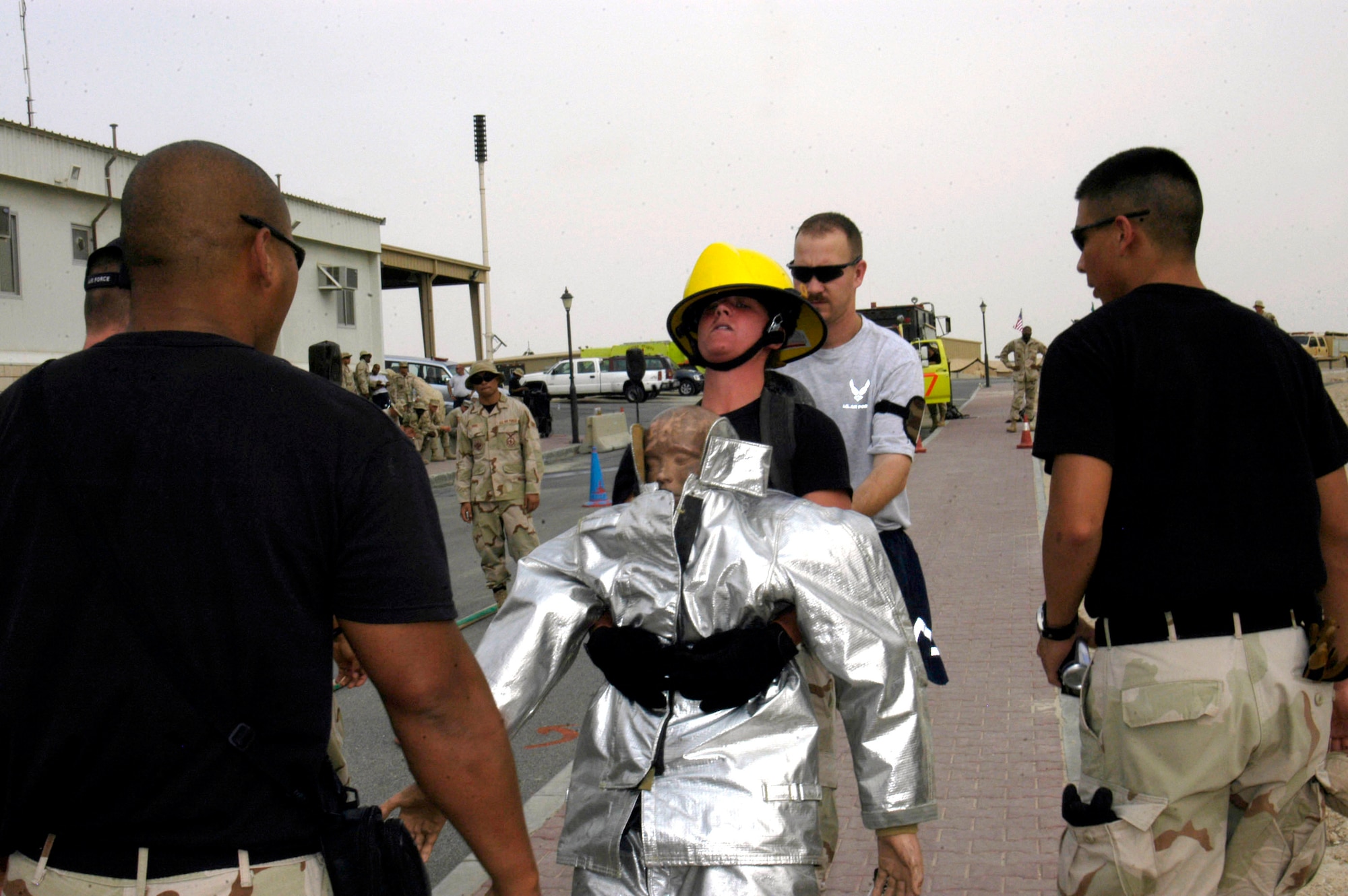 Airman 1st Class Michelle McCarty is encouraged to keep moving as she pulls a 135-pound dummy 100 feet at the Firefighter Challenge in Southwest Asia on Thursday, May 4, 2006. More than 36 Airmen, Marines and Soldiers participated in the event, which was hosted by the 386th Air Expeditionary Wing fire and emergency services flight. Individual and team events included climbing a 40-foot tower to hoist a 40-pound hose and pulling a hose 75 feet, which when extended weighs more than 270 pounds. Airman McCarty is assigned to the 386th Security Forces Squadron force protection flight. (U.S. Air Force photo/Staff Sgt. Jasmine Reif)