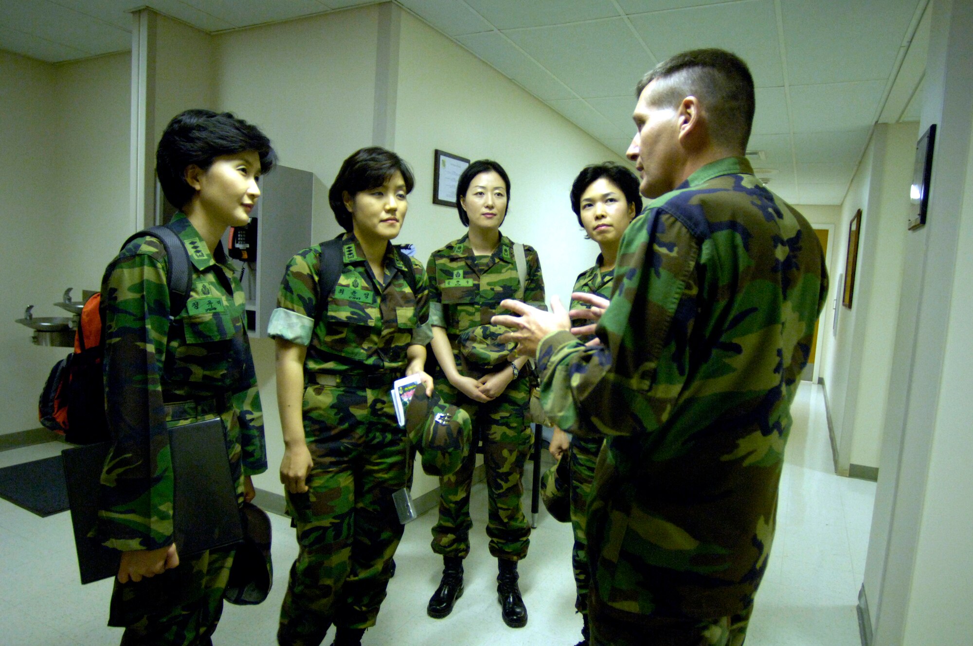 Lt. Col. David Beavers explains the operation of the William R. Schick Clinic to four visiting South Korean Air Force nurses at Hickam Air Force Base, Hawaii, on Tuesday, April 25, 2006. South Korea sent seven nurses to the island to discuss mass casualty response, civil-military coordination and biohazard response procedures for natural disaster management. The colonel is the chief nurse at the clinic and is assigned to the 15th Medical Group. (U.S. Air Force photo/Tech. Sgt. Shane A. Cuomo)