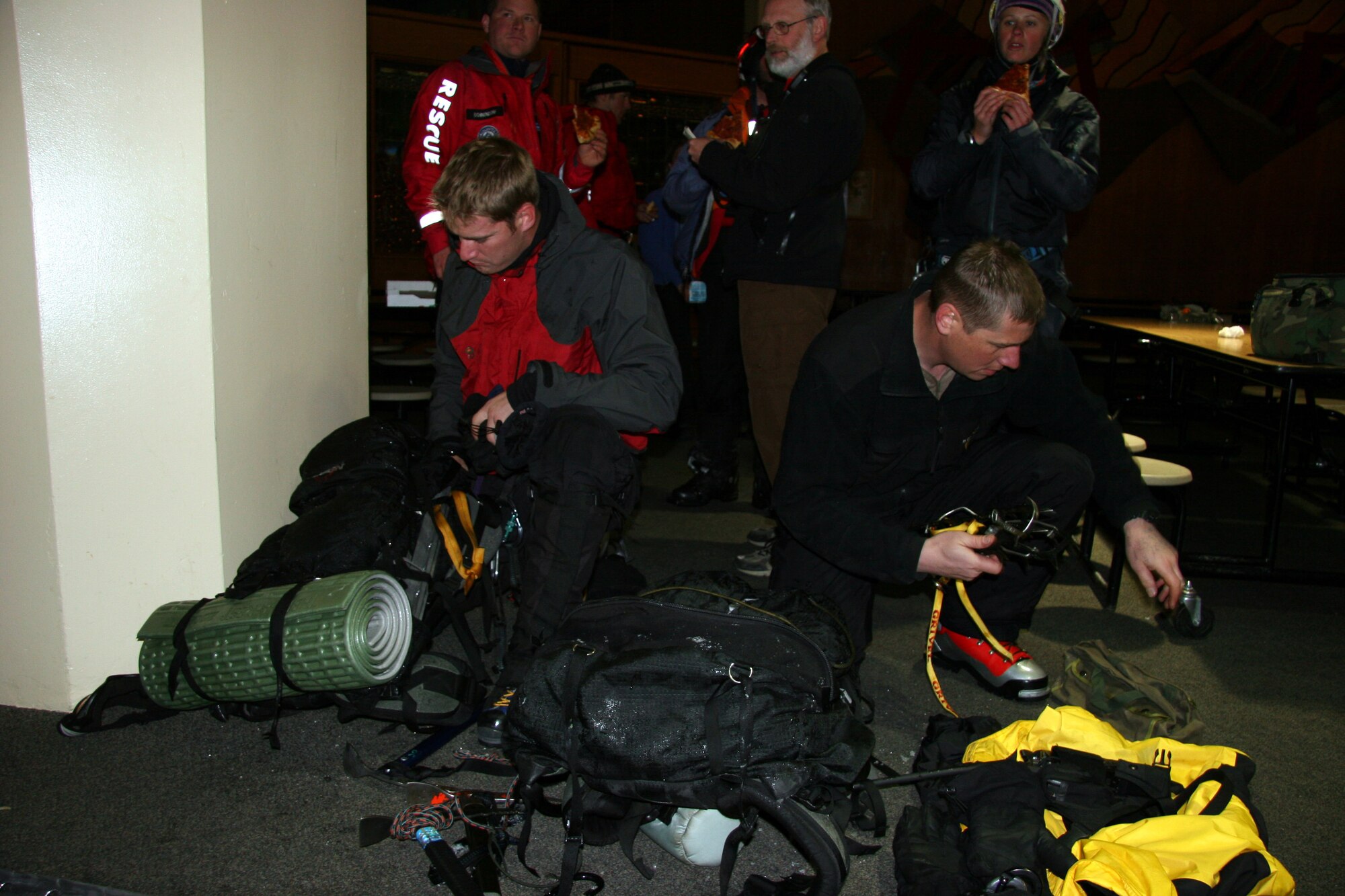 Staff Sgt. Josiah Blanton, left and Staff Sgt. John Davis pack up their gear they used to help rescue a man who was injuried in a skiing accident on Mount Hood, Ore. May 6, 2006.  The medical supplies and rescue gear the pararescuemen use weighs more than 50 pounds and is carried in packs on their backs. (U.S. Air Force Photo/Master Sgt. Ruby Zarzyczny)