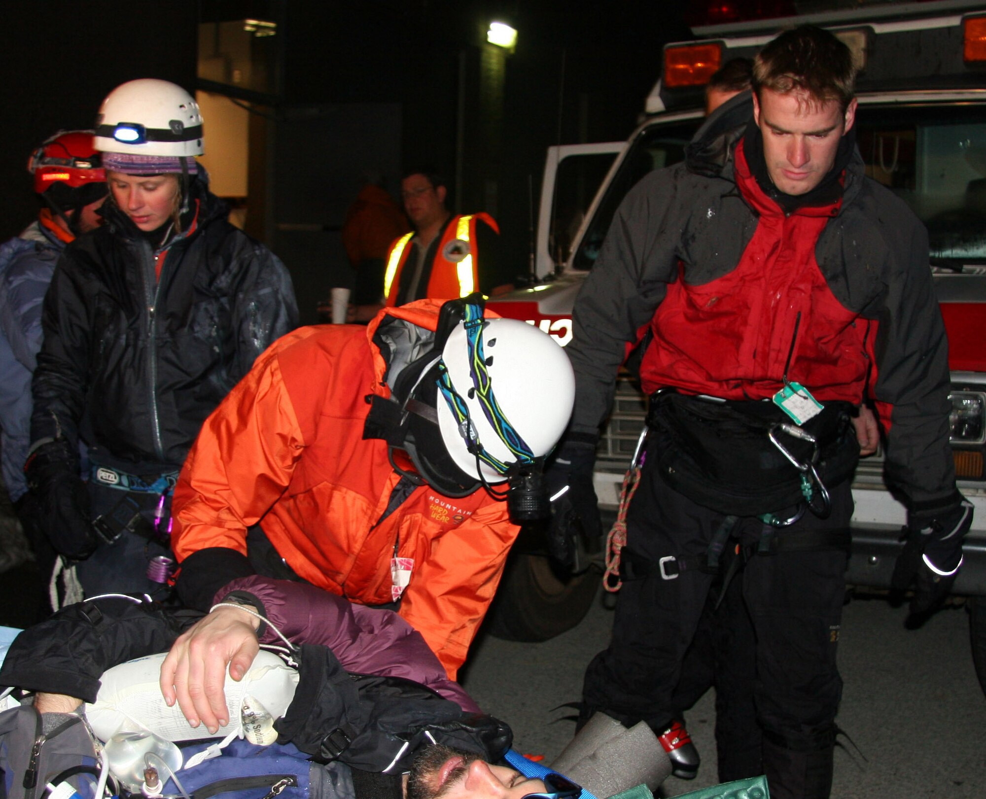 After climbing for hours on Mount Hood, Tech. Sgt. Kevin Baum, center and Staff Sgt Josiah Blanton, (right) 304th Rescue Squadron Pararescuemen who were part of a 15-member rescue team comprised of volunteers from the Portland Mountain Rescue and members of the AMR Reach and Treat team, help get the patient into a waiting ambulance to be transported to a local hospital May 6, 2006. (U.S. Air Force Photo/ 