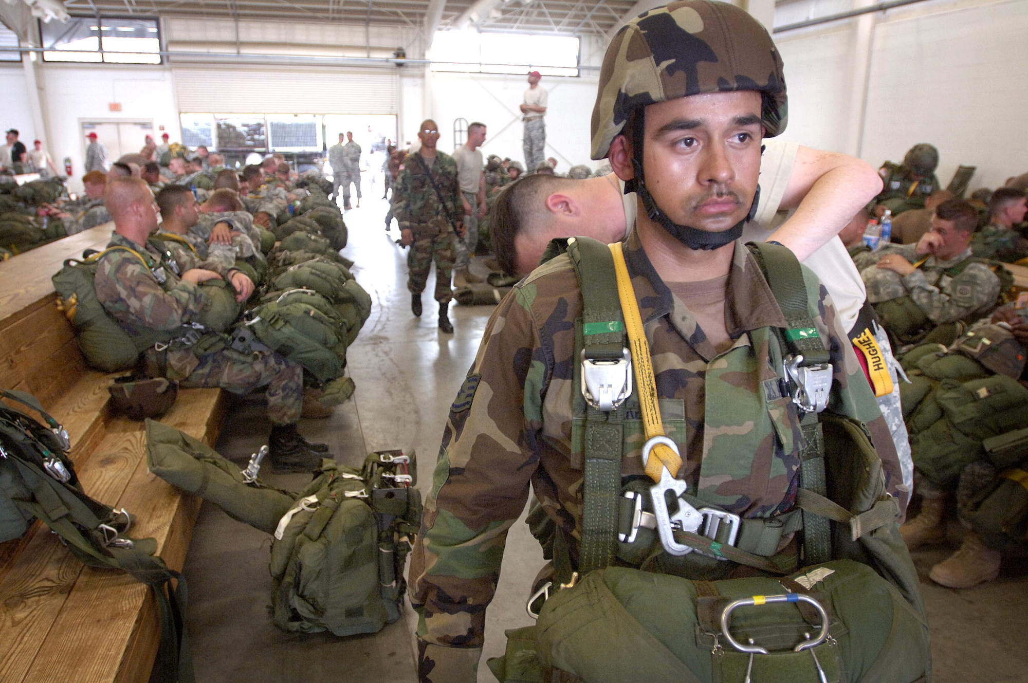 Staff Sgt. Flavio Perez has his chute rigging inspected by jumpmaster Army Lt. Col. William Hughes before a jump at Fort Bragg, N.C., on Wednesday, April 25, 2006. Airmen and more than 2,000 Soldiers from the Army's 82nd Airborne Division were taking part in a Joint Forcible Entry Exercise. Sergeant Perez is an airborne electrical systems journeyman with the 820th Red Horse Squadron at Nellis Air Force Base, Nev. Thirty other jump-qualified Air Force engineers, firefighters and security forces Airmen assisted in security and rapid runway repair. (U.S. Air Force photo/Master Sgt. Scott Wagers)