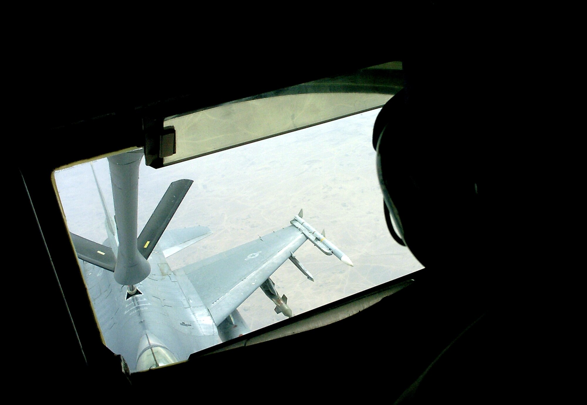 An F-16 Fighting Falcon flies into position as Airman Morgan Clover lowers the refueling boom of a KC-135 Stratotanker on Sunday, May 7, 2006, over Iraq. Airman Clover is deployed to the 340th Expeditionary Air Refueling Squadron in Southwest Asia from McConnell Air Force Base, Kan. (U.S. Air Force photo/Senior Airman Brian Ferguson)