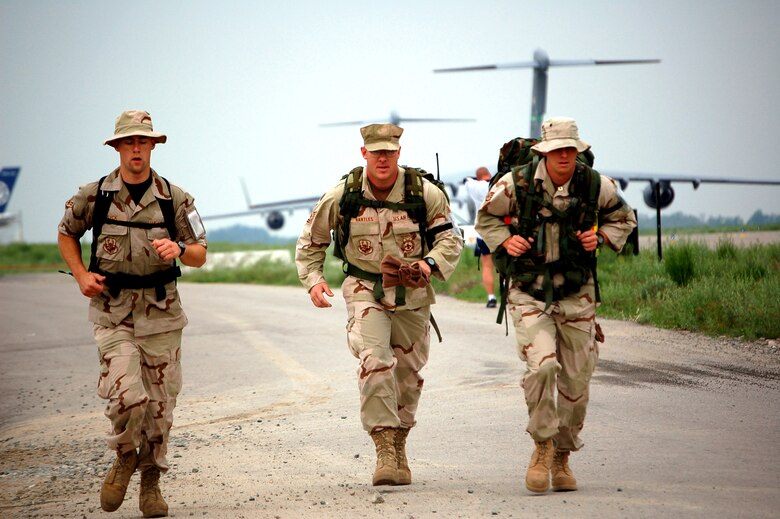 (From left) Airman 1st Class Sean Syck, Tech. Sgt. Brian Bartles and Staff Sgt. Michael Tyburski run in the Bloomsday Away 12K race at Manas Air Base, Kyrgyzstan, on Sunday, May 7, 2006. The Bloomsday race is annual tradition in Spokane, Wash. This year, Airmen brought their own version of the race to Manas. The three firefighters are with the 376th Expeditionary Civil Engineer Squadron. While they finished among the last, they were probably the first to run the Bloomsday in full military uniform with 50-pound rucksacks. (U.S. Air Force photo/Staff Sgt. Lara Gale)