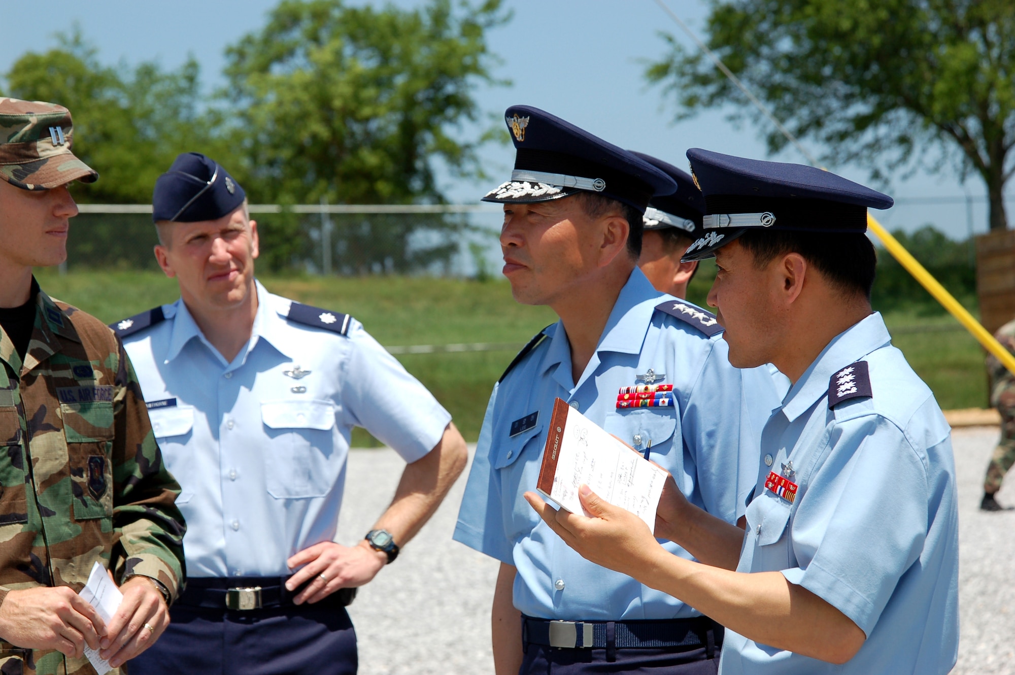 (From left) Capt. Kenneth Walker and Lt. Col. Kim Hawthorne discuss training activities on Monday, May 1, 2006, with Lt. Gen. Youngha Lee and Col. Mukyum Kim at Maxwell-Gunter Air Force Base, Ala. Captain Walker and Colonel Hawthorne are with the Officer Training School. General Lee is commander of the Republic of South Korea Headquarters for Air Force Education and Training Command in Jinju. Colonel Kim is the air attache to the United States' Korean Embassy in Washington, D.C. (U.S. Air Force photo/Tech. Sgt. Scott Moorman) 
