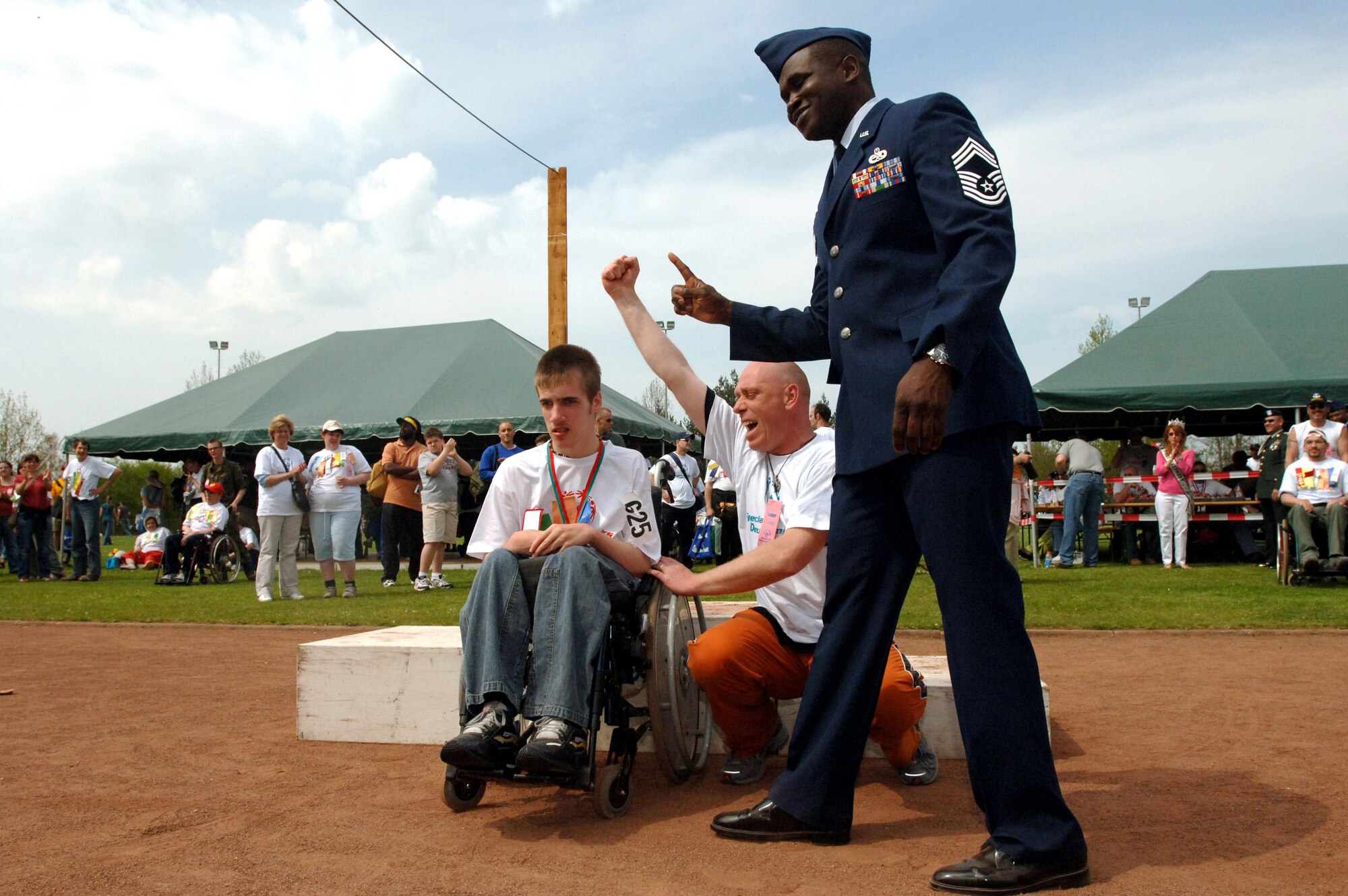 Chief Master Sgt. Reginald Glover helps celebrate during the medal presentations at the 29th Special Olympics at Enkenbach-Alsenborn, Germany, on Wednesday, May 3, 2006. Chief Glover is with the 86th Maintenace Group at Ramstein Air Base, Germany. He said that "to see these kids feel the feeling of satisfaction and pride was an awesome experience." Nearly 200 Airmen and Soldiers stationed in southwestern Germany joined German volunteers to make the games a successful event for the athletes. (U.S. Air Force photo/Master Sgt. John E. Lasky)