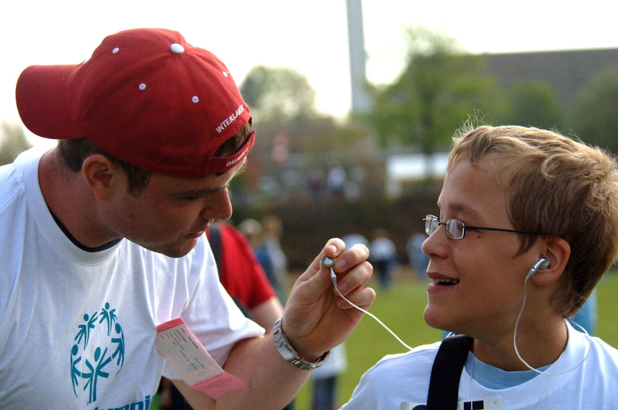 Senior Airman Kenneth York listens to the music on Maurice's headset before the start of the Special Olympics opening ceremonies at Enkenbach-Alsenborn, Germany, on Wednesday, May 3, 2006. This is the 29th time the games were held in this part of Germany. Volunteers usually outnumber the athletes. Airman York, from Knoxville, Tenn., is with the 435th Logistics Readiness Squadron at Ramstein Air Base, Germany. (U.S. Air Force photo/Master Sgt. John E. Lasky)