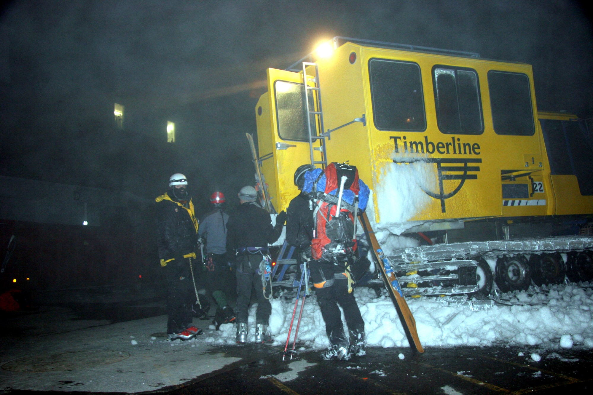 Tech. Sgt. John Davis (far left) waits outside a snow cat for other members of a rescue team on Mount Hood, Ore., on Saturday, May 6, 2006. The Air Force Reserve Command's 304th Rescue Squadron in Portland, Ore., was called out to help local rescue teams recover a man who fell down a 300-foot slope while skiing on Mount Hood. Sergeant Davis is a pararescueman with the 304th RQS. (U.S. Air Force photo/Master Sgt. Ruby Zarzyczny)