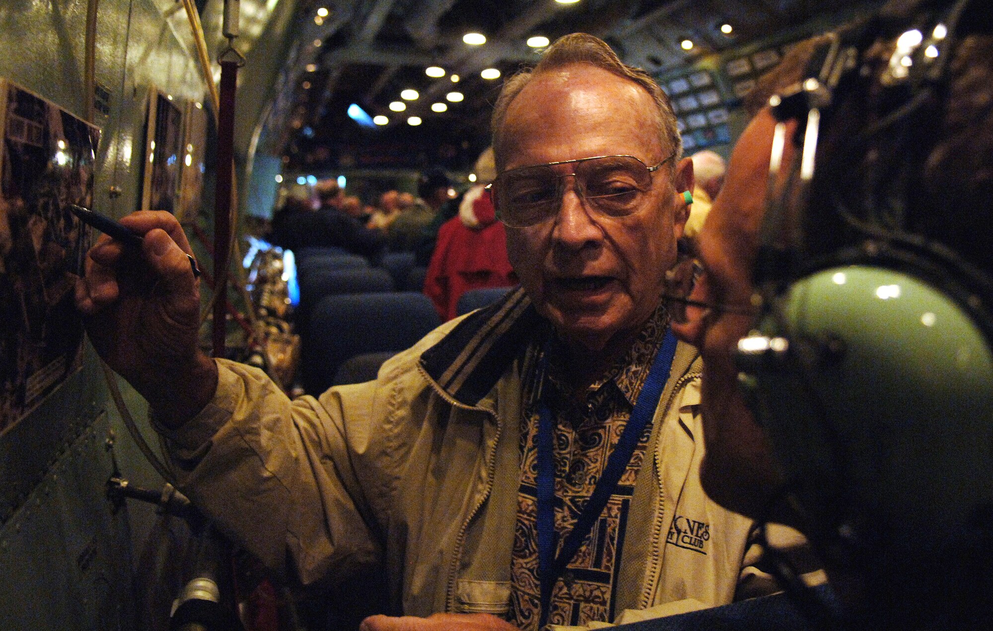 Jim Lamar (left) talks to Tech. Sgt. Rick Sforza on Saturday, May 6, 2006, about an aerial photograph of the "Hanoi Hilton" prisoner of war camp where he was held captive in Vietnam. The two men were flying on the final mission of the C-141 "Hanoi Taxi" over Wright-Patterson Air Force Base, Ohio. Sergeant Sforza is a Reserve photographer with the 4th Combat Camera Squadron. (U.S. Air Force photo/Tech. Sgt. Larry A. Simmons)