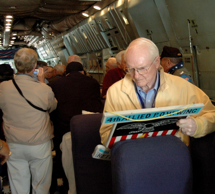 WRIGHT-PATTERSON AFB, Ohio -- Former Vietnam POW retired Air Force Col. Ben Pollard signs the back of the 4th Allied POW Wing emblem before a flight aboard the Hanoi Taxi with 57 other POWs flown by the Air Force Reserve's 445th Airlift Wing. (U.S. Air Force Reserve photo by TSgt. Charlie Miller)
