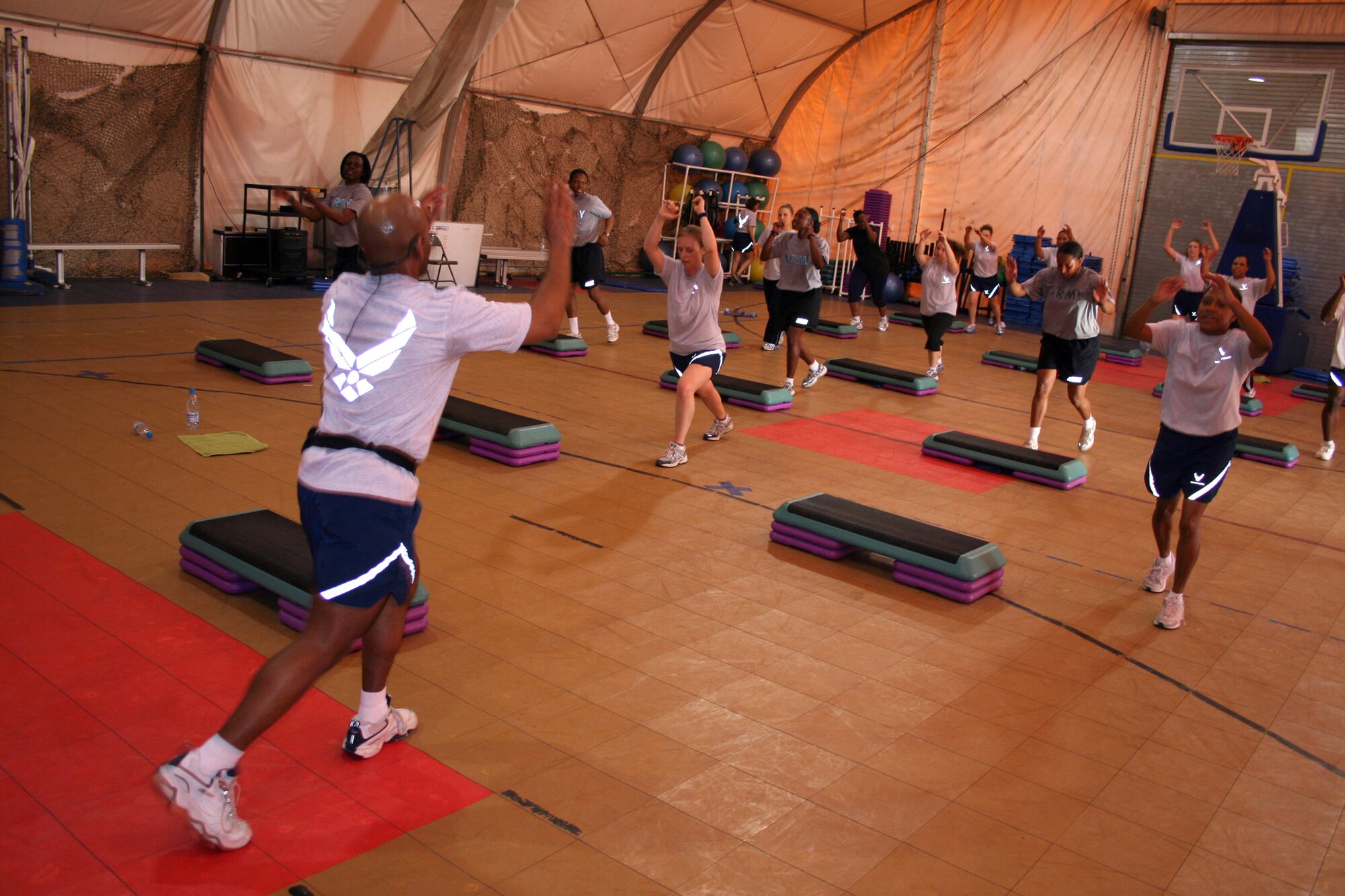 Staff Sgt. Daryl Watkins leads Airmen in a step-aerobics class at the fitness center at Manas Air Base, Kyrgyzstan. The center's classes are popular with permanent party and transient personnel. (U.S. Air Force photo/Staff Sgt. Lara Gale) 
