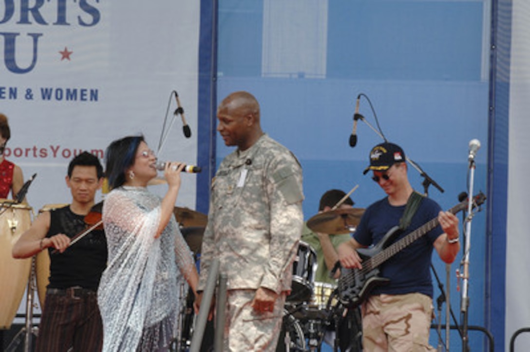 A singer from Gary Sinise's Lt. Dan Band serenades a soldier during a concert at the Pentagon on May 5, 2006. Deputy Secretary of Defense Gordon England presented the Superior Public Service Award to Sinise prior to the concert in recognition of his work with the United Service Organizations tours and his visits with wounded heroes at Walter Reed Army Medical Center and the National Navy Medical Center. Sinise also co-founded the Operation Iraqi Children with author Laura Hillenbrand, in an effort to help educate Iraqi children. 