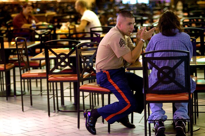 Sgt. James Thyden, recruiter from Alexandria, Va. talks with a potential recruit Andy Thong, a 24-year-old grocery store clerk, in the food court of Springfield Mall in Alexandria May 9, 2006. Recruiters are often faced with the task of continuously finding able bodies throughout the year to fill the needs of the Marine Corps. It is a task that often starts early in the morning and ends sometimes late in the night.