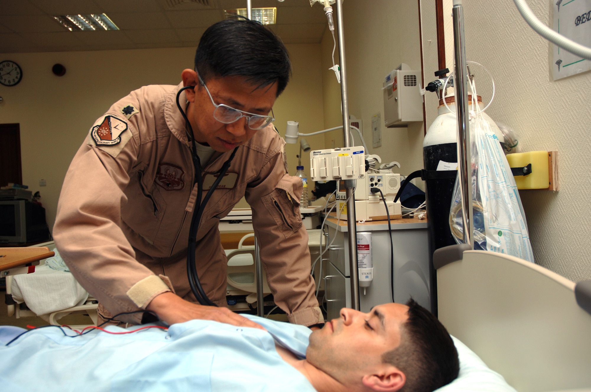 Lt. Col. (Dr.) Paul Doan, chief of aerospace medicine for the 379th Expeditionary Medical Group in Southwest Asia, evaluates Roberto Leal. Dr. Doan is a former war refugee from Vietnam. He is deployed from Barksdale Air Force Base, La. (U.S. Air Force photo/Staff Sgt. Joshua Strang) 

