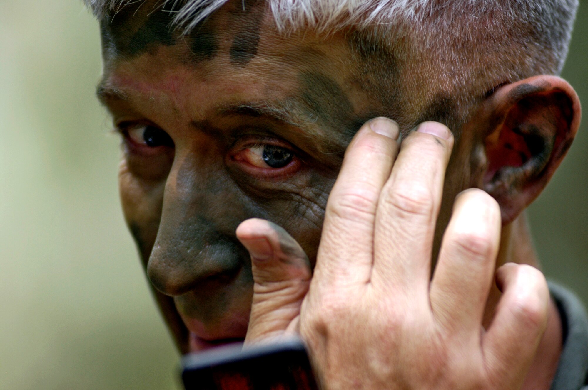 Lt. Col. Jimmy Barrow applies grease paint to camouflage his face during a ground survival refresher course at Schofield Barracks, Hawaii, on Thursday, May 4, 2006. The course provides realistic training for aircrew members and concentrates on the principles, techniques and skills necessary to survive in any environment. (U.S. Air Force photo/Tech. Sgt. Shane A. Cuomo)