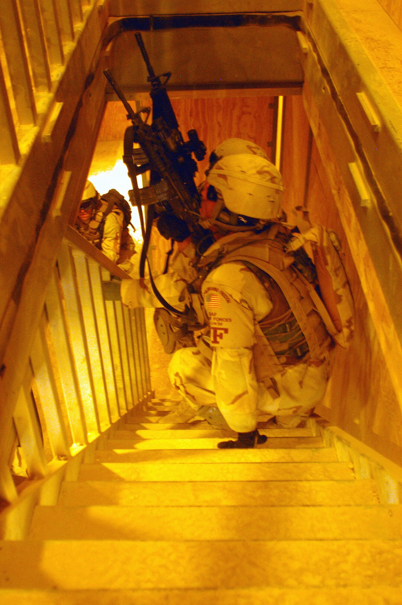 Senior Airmen Victor Morales (foreground) and Charles Coles check a stairwell for simulated enemy forces during Military Operations in Urban Terrain training at Bagram Air Base, Afghanistan, on Tuesday, May 9, 2006. The facility, run by the U.S. Army here, is a mock Afghan village designed to train and test U.S. and coalition forces' skills in close combat. The Airmen are with the 455th Expeditionary Security Forces Squadron. (U.S. Air Force photo/Maj. David Kurle)