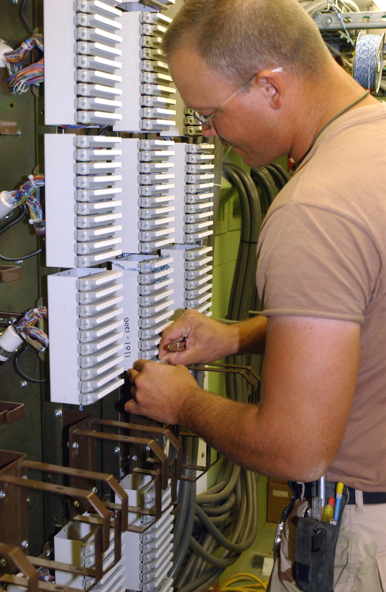 Staff Sgt. Lee Doolen connects jumper cables to telephone circuits in the main distribution frame at Ali Base, Iraq, on Friday, May 6, 2006. Sergeant Doolen is deployed to the 407th Expeditionary Communications Squadron at Tinker Air Force Base, Okla. (U.S. Air Force photo/Master Sgt. Jon Hanson)