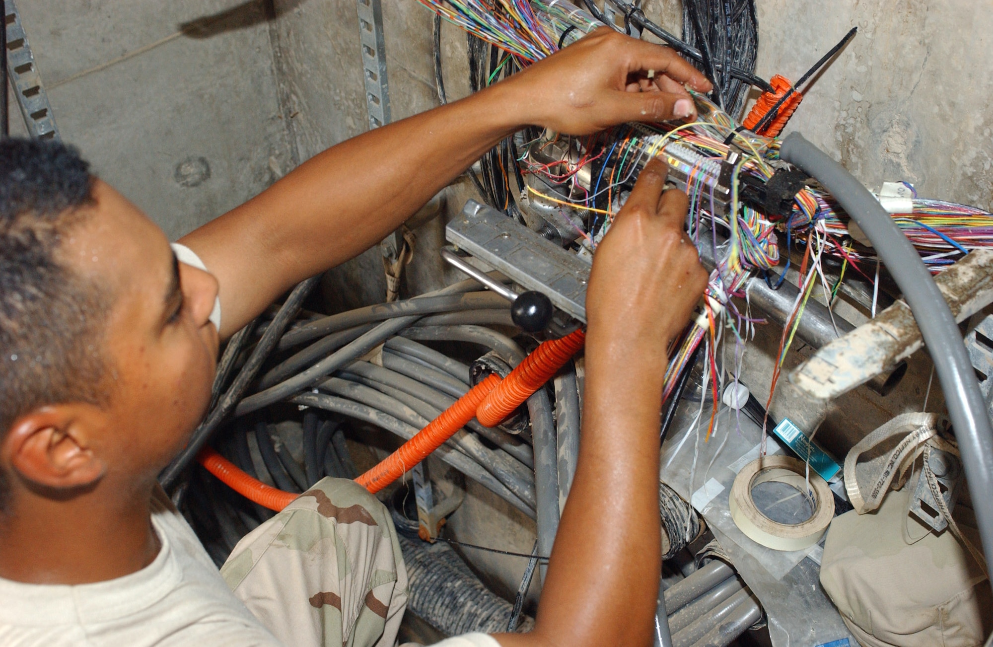 Staff Sgt. David Reyes splices copper cables on a splice machine at Ali Base, Iraq, on Friday, May 5, 2006. Sergeant Reyes is deployed to the 407th Expeditionary Communications Squadron from F.E. Warren Air Force Base, Wyo. (U.S. Air Force photo/Master Sgt. Jon Hanson) 

