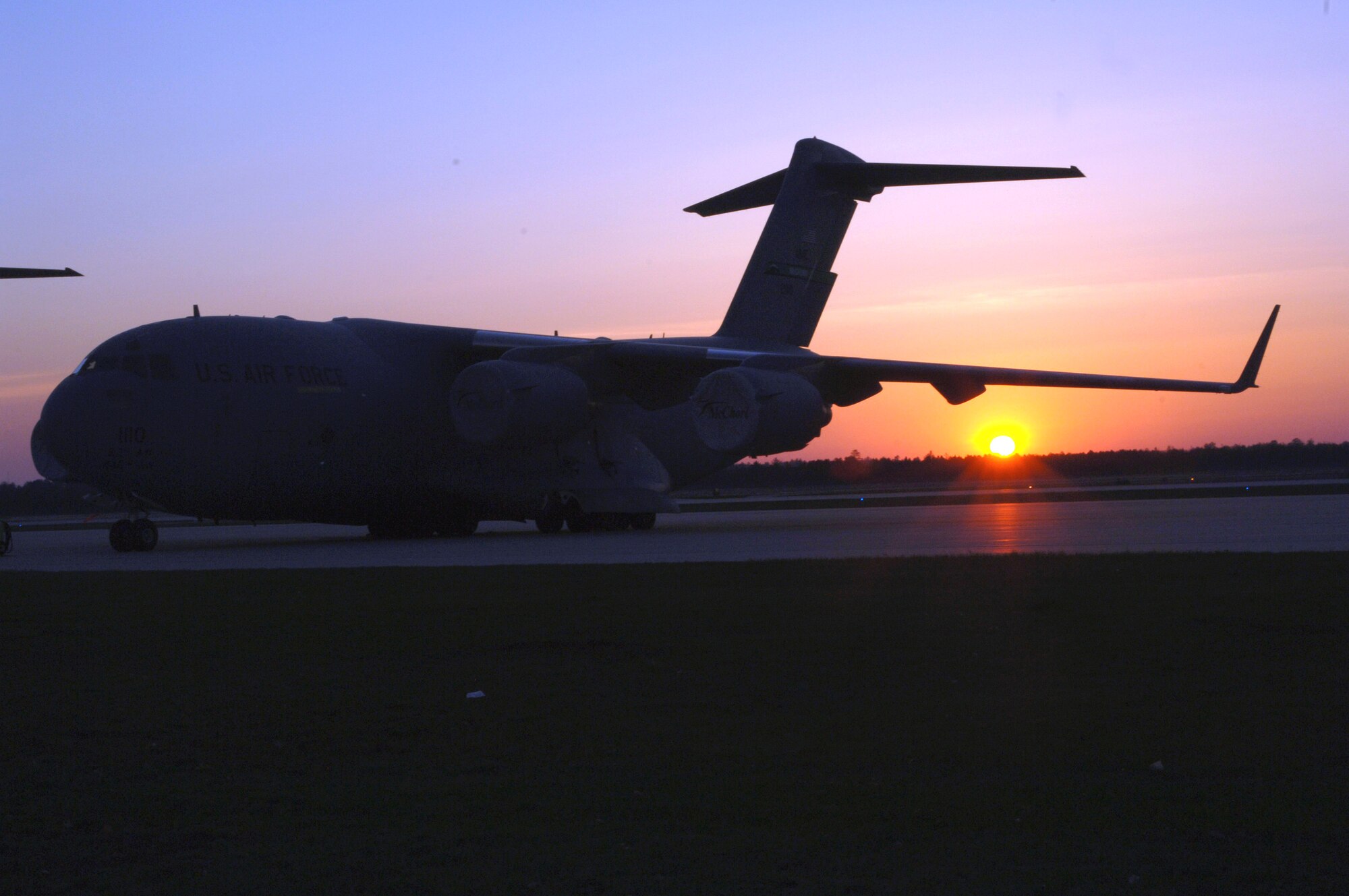 A C-17 Globemaster III from the 62nd Airlift Wing at McChord Air Force Base, Wash., sits on the runway as the sun rises in Alpena, Mich., during Exercise Thunderbolt on Tuesday, May 9, 2006. (U.S. Air Force photo/Airman 1st Class Chad M. Kellum) 
