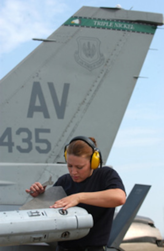 U.S. Air Force Airman 1st Class Theresa Waterfield installs wings and fins on an AIM-120 advanced medium-range air-to-air missile during a weapons load competition at Aviano Air Base, Italy, on May 5, 2006. Waterfield is attached to the 31st Aircraft Maintenance Squadron at Aviano. 