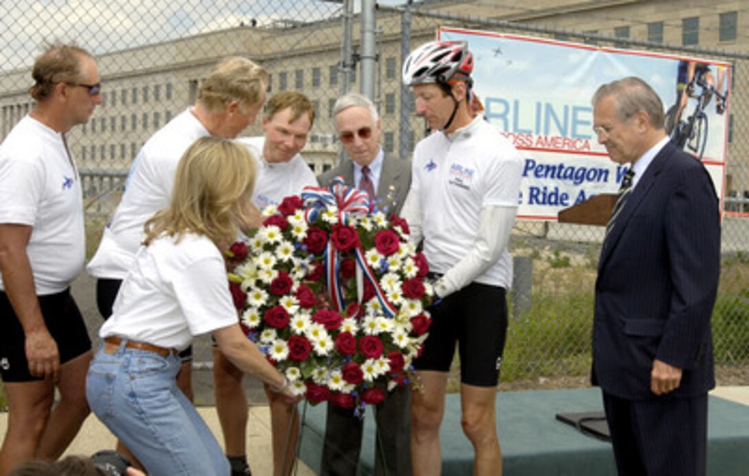 Deputy Secretary of Defense Gordon England (3rd from right), Thomas Heidenberger (2nd from left), and other airline employees place a wreath near the site of the impact of American Airlines Flight 77 at the Pentagon as Secretary of Defense Donald H. Rumsfeld (right) watches on May 9, 2006. The cyclists departed Los Angeles on April 2, and dedicated each of the 33 days of the ride to the memory of a particular airline crew member killed in the terrorist actions of Sept. 11, 2001. 