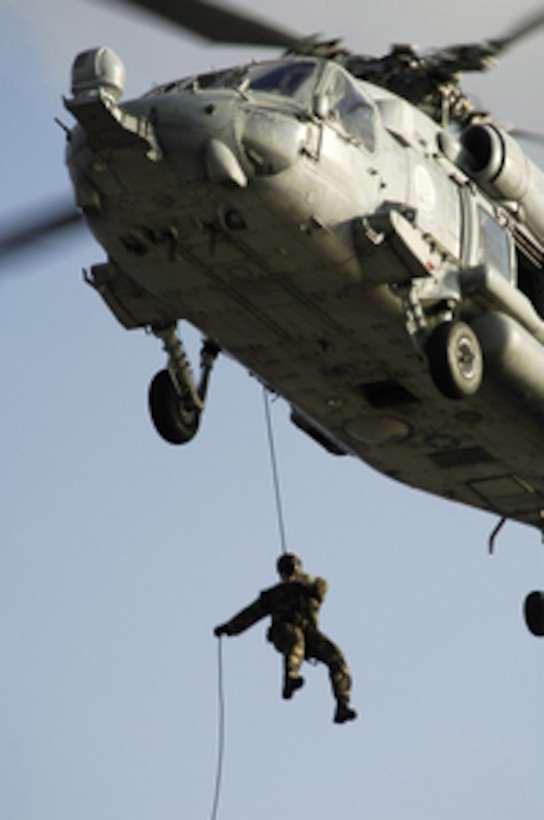 A U.S. Navy sailor with Explosive Ordnance Disposal Detachment 9 rappels from an HH-60H Seahawk helicopter to the flight deck of the aircraft carrier USS Abraham Lincoln (CVN 72) on May 10, 2006. The Lincoln and embarked Carrier Air Wing 2 are operating in the South China Sea. 