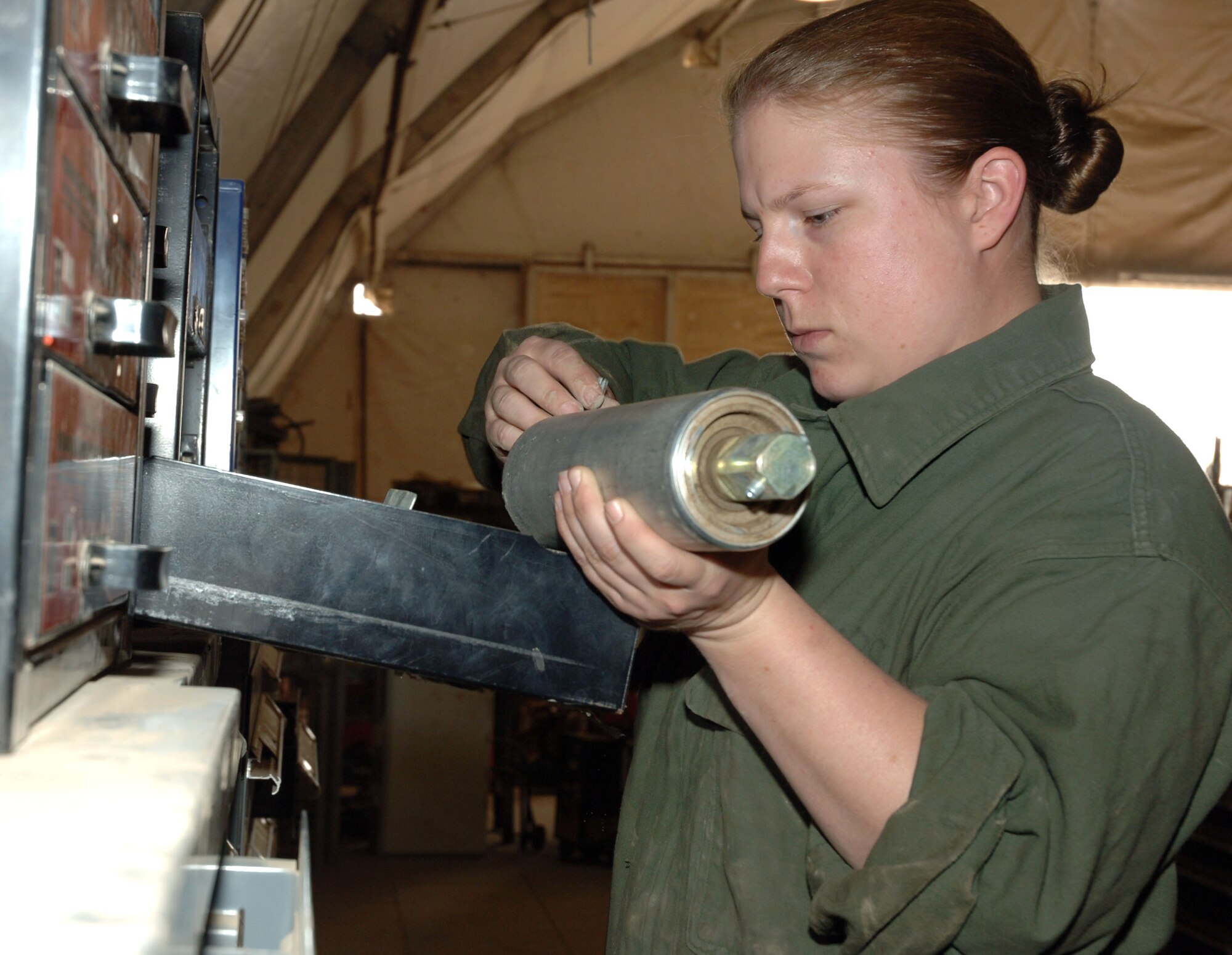 Staff Sgt. Jamie Thompson looks for a part for a K-loader roller at Sather Air Base, Iraq, on Monday, May 1, 2006. She is a mechanic with the 447th Expeditionary Logistics Readiness Squadron vehicle maintenance flight. (U.S. Air Force photo/Master Sgt. Will Ackerman)
