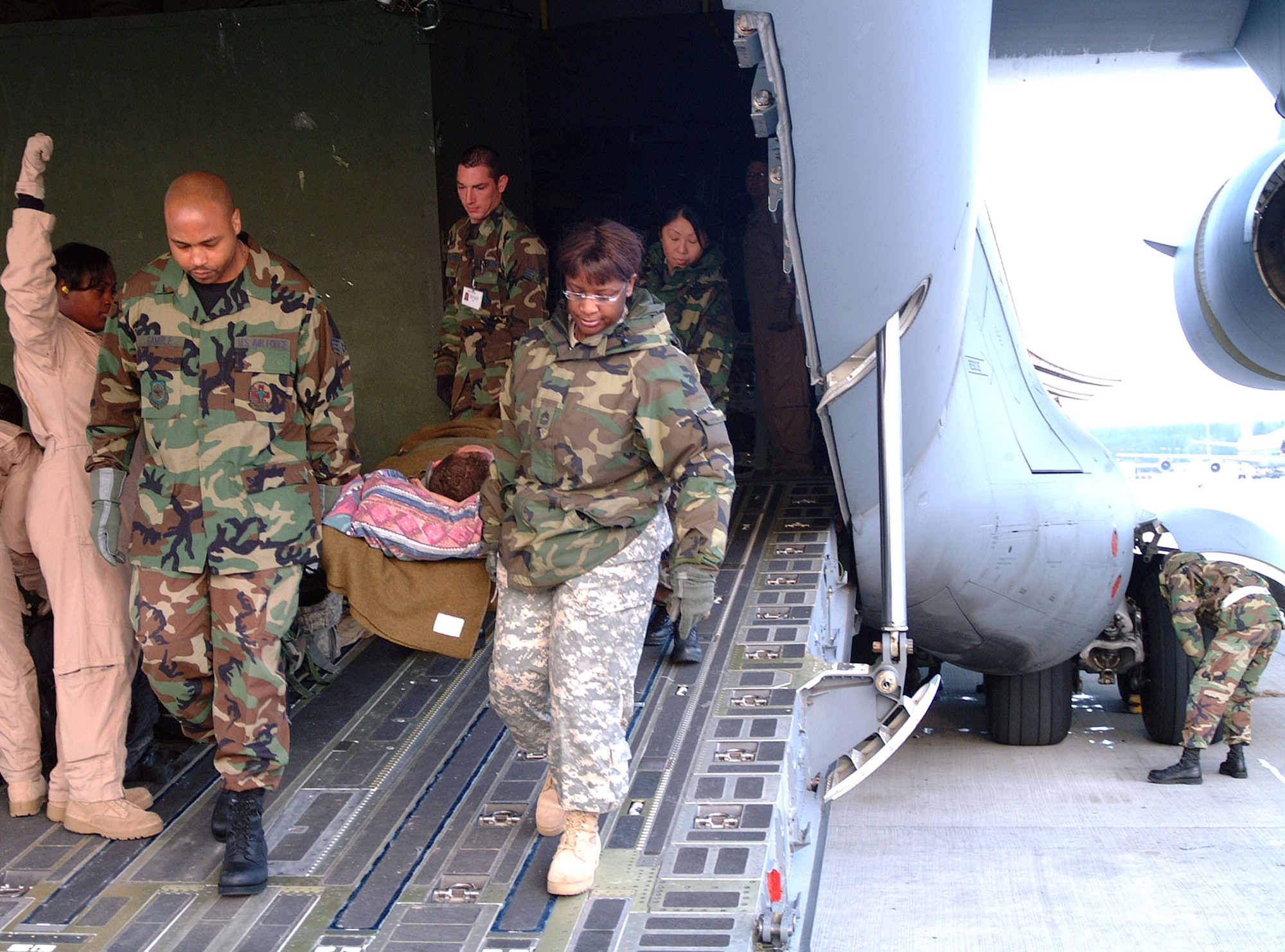 A contingency air staging facility medical team carries a wounded servicemember off a C-17 Globemaster III at Ramstein Air Base, Germany, after a recent flight from Balad Air Base, Iraq.  Medics then transport patients to nearby Landstuhl Regional Medical Center for further treatment and recovery.  (U.S. Air Force photo/David Kellogg)