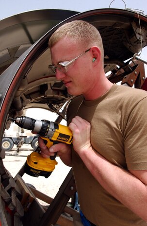 Senior Airman Benjamin Carter drills out a fastener on the thrust reverser door of a C-17 Globemaster III at a desert base on Tuesday, May 2, 2006.  Airman Carter is a sheet metal technician deployed to the 379th Expeditionary Maintenance Squadron from Charleston Air Force Base, S.C. (U.S. Air Force photo/Senior Airman Rachel Walters) 
