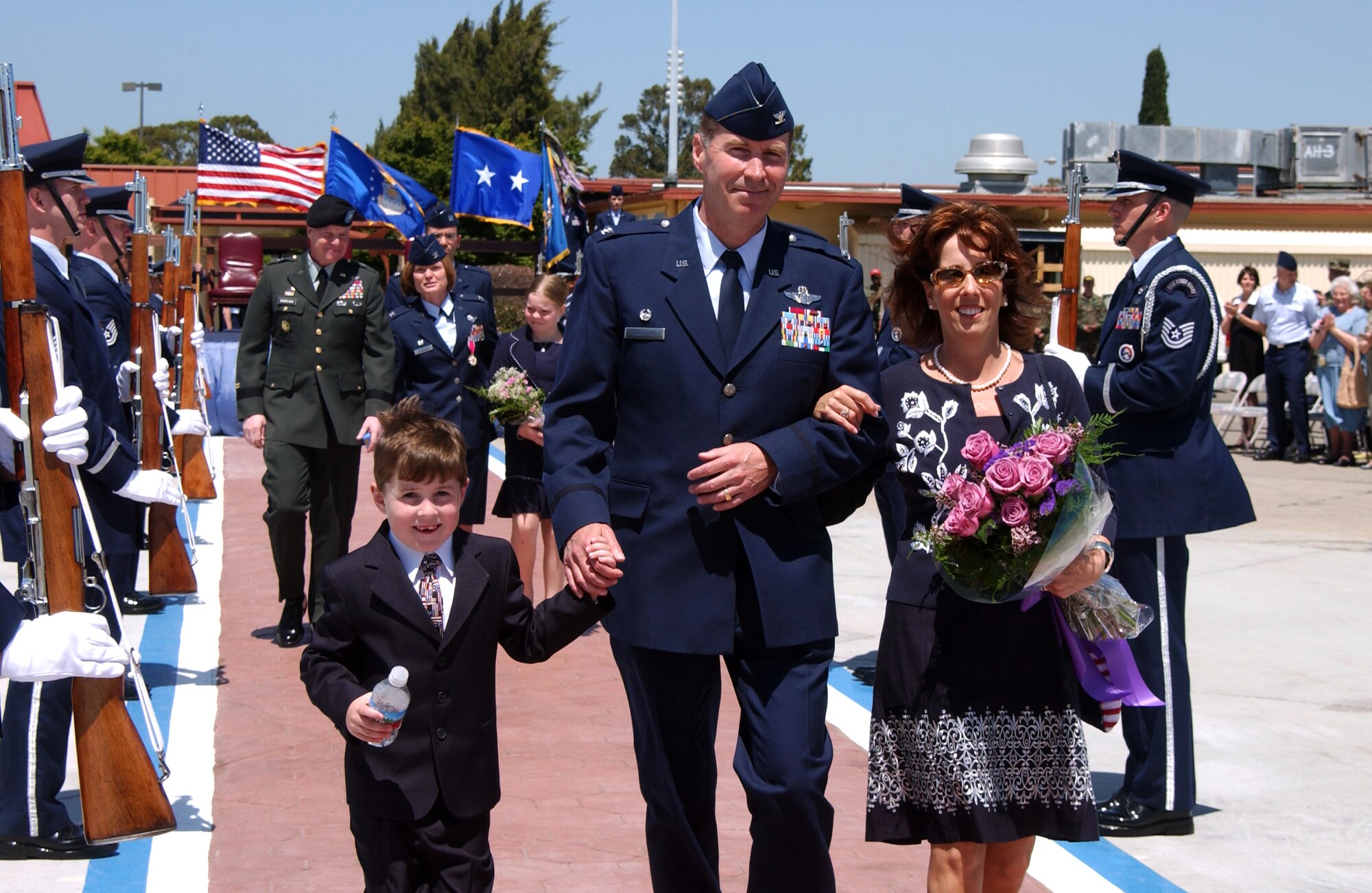 Col. Steven Arquiette, 60th Air Mobility Wing’s new commander, his wife, Deb, and their son, Stevie, depart the ceremony, with Col. Lyn Sherlock, 60th AMW’s outgoing commander, her husband, Reserve Army Brig. Gen. Richard Sherlock and their daughter, Heather, following. (U.S. Air Force photo by Nan Wylie)
