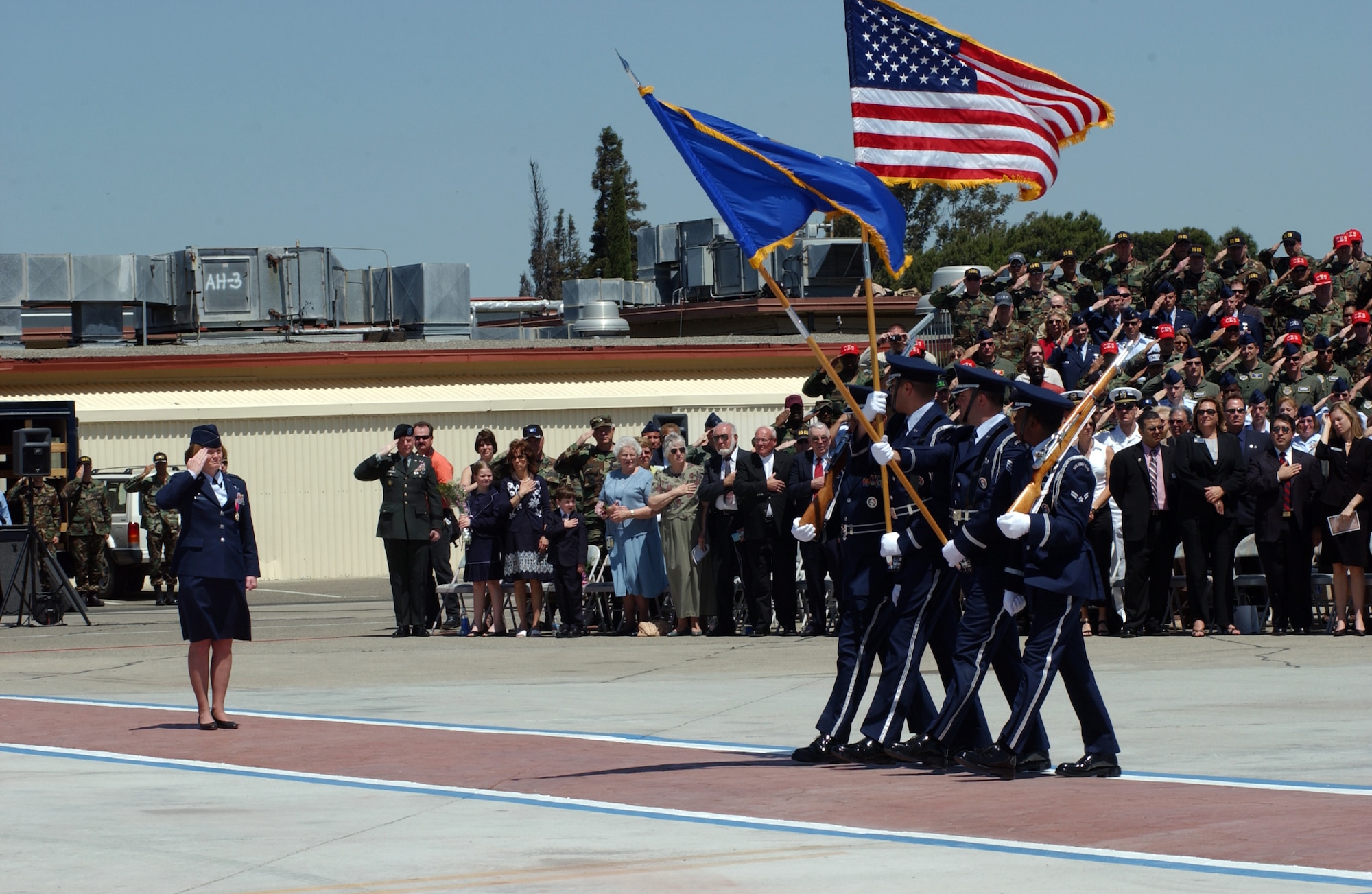 Col. Lyn Sherlock, 60th Air Mobility Wing’s outgoing commander, salutes members of the Travis Color Guard as they pass by during the parade portion of the ceremony. (U.S. Air Force photo by Nan Wylie)