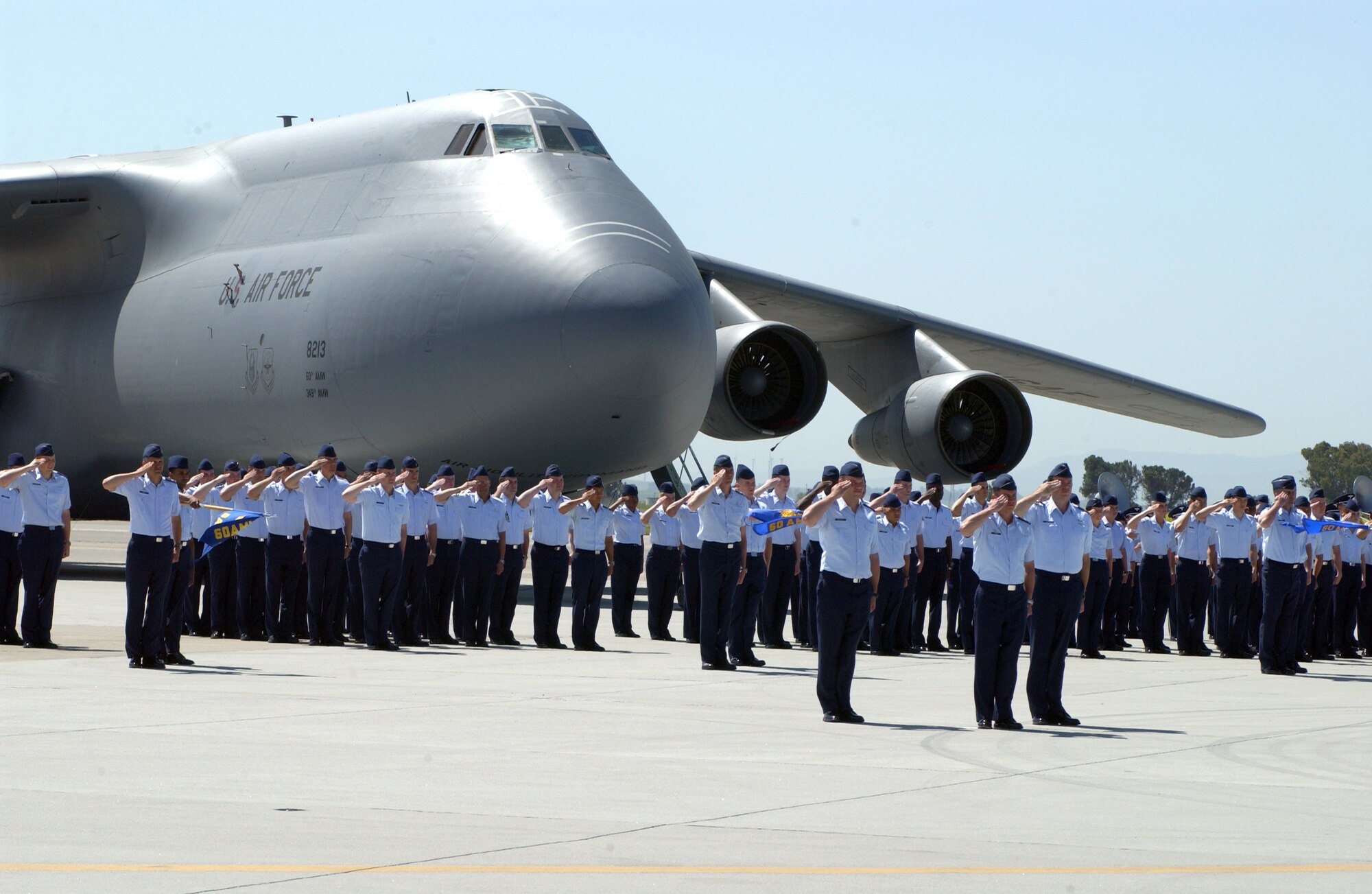 A formation of Travis members from various squadrons salutes the 60th Air Mobility Wing’s outgoing commander, Col. Lyn Sherlock. (U.S. Air Force photo by Andre Mansour)