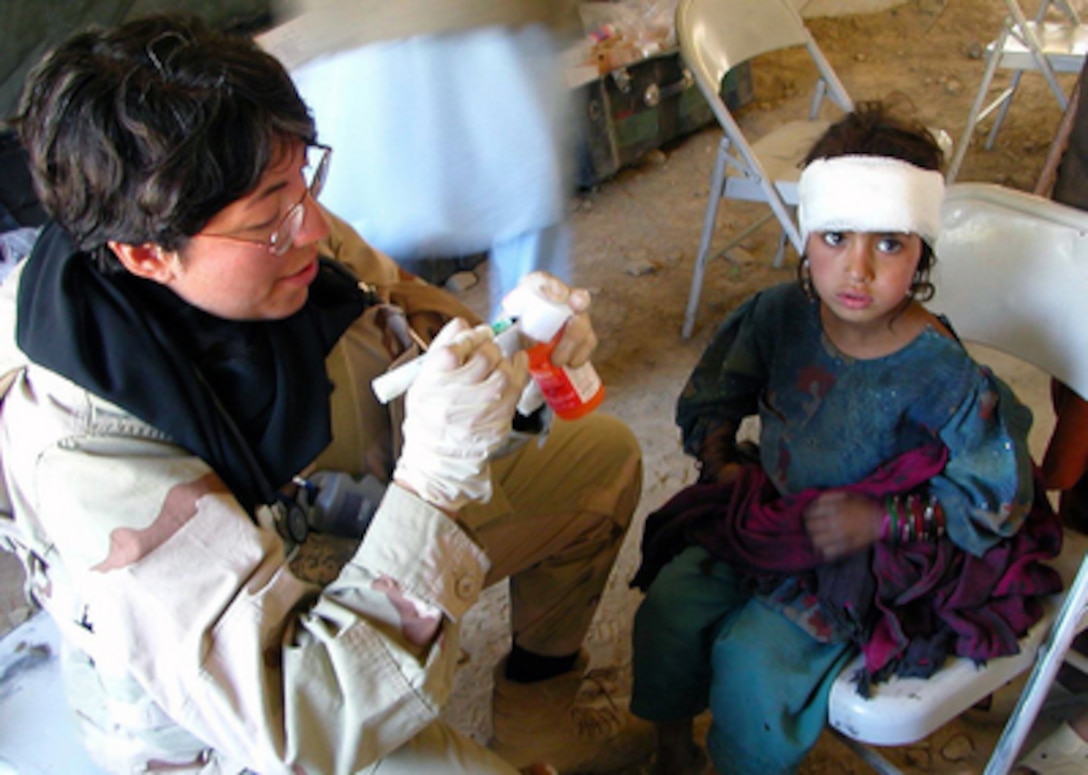 U.S. Navy Cmdr. Sandra Hearn treats an Afghan girl with a head injury in Jalalabad, Afghanistan, on April 21, 2006. Hearn is assigned to the cooperative medical assistance team for Combined Joint Task Force 76. 