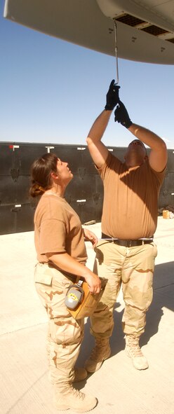 BAGRAM AIRFIELD, Afghanistan -- Tech. Sgt. Christine Nicewander, left, and Staff Sgt. Mitch Rice, both munitions loaders deployed to the 455th Expeditionary Maintenance Squadron here, remove chaff and flare boxes from the wing tip of an A-10 Thunderbolt II May 13 shortly after its arrival for an Aerospace Expeditionary Force deployment in support of Operation Enduring Freedom.  Both sergeants are Air Force reservists deployed from the 442nd Fighter Wing, Whiteman Air Force Base, Mo.  (US Air Force photo by Maj. David Kurle, 455 AEW/PA)